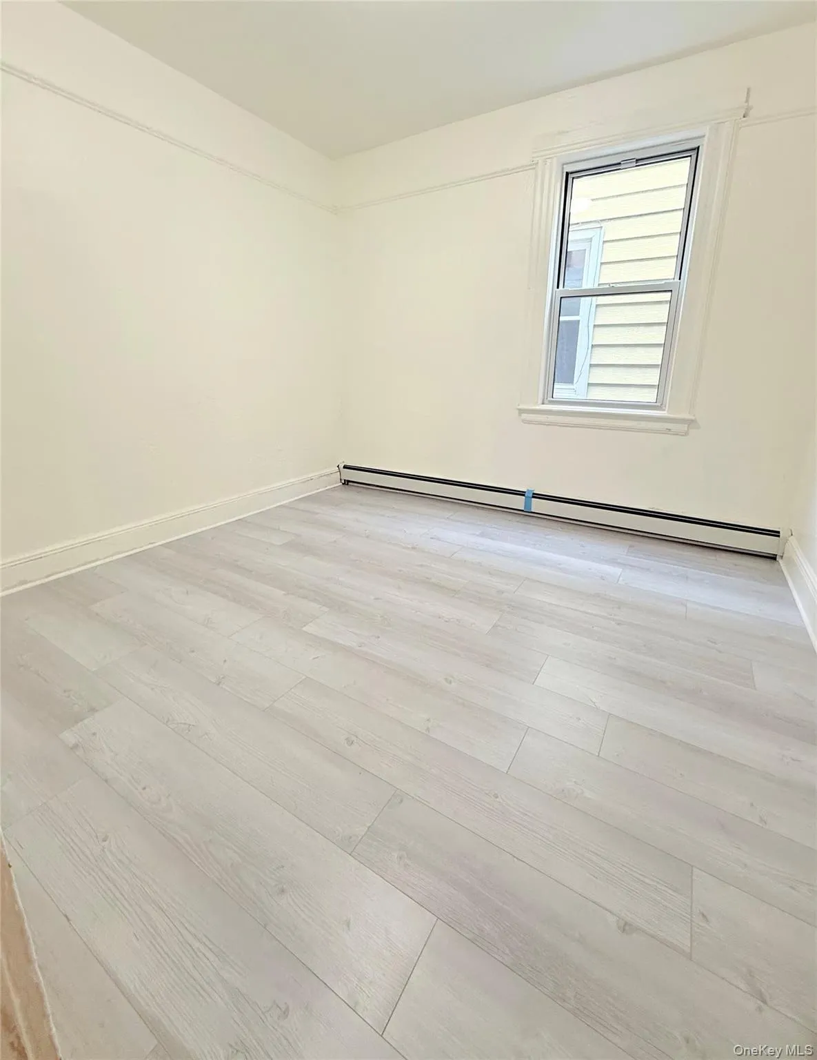 Spare room featuring a baseboard radiator and light wood finished floors Spare room featuring a baseboard radiator and light wood finished floors