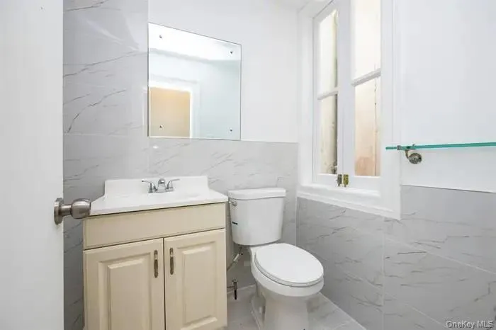 Bathroom featuring tile walls and vanity Bathroom featuring tile walls and vanity