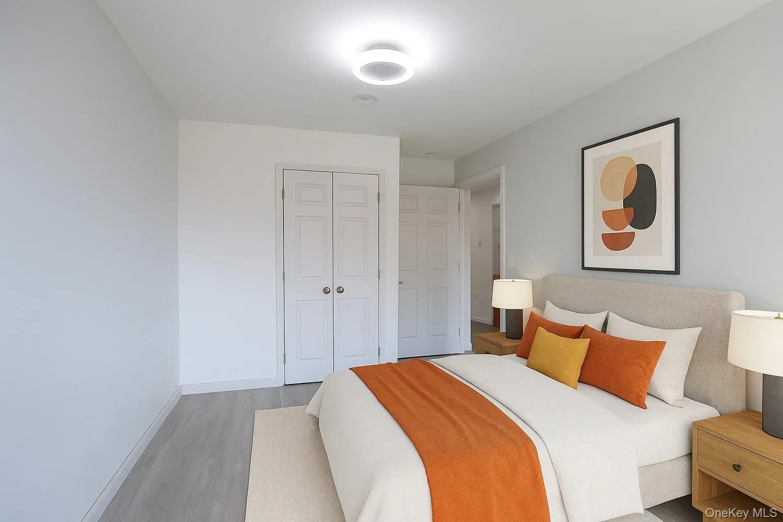 Virtually staged photo of bedroom featuring wood finished floors, a closet, and virtually staged modern furniture Virtually staged photo of bedroom featuring wood finished floors, a closet, and virtually staged modern furniture