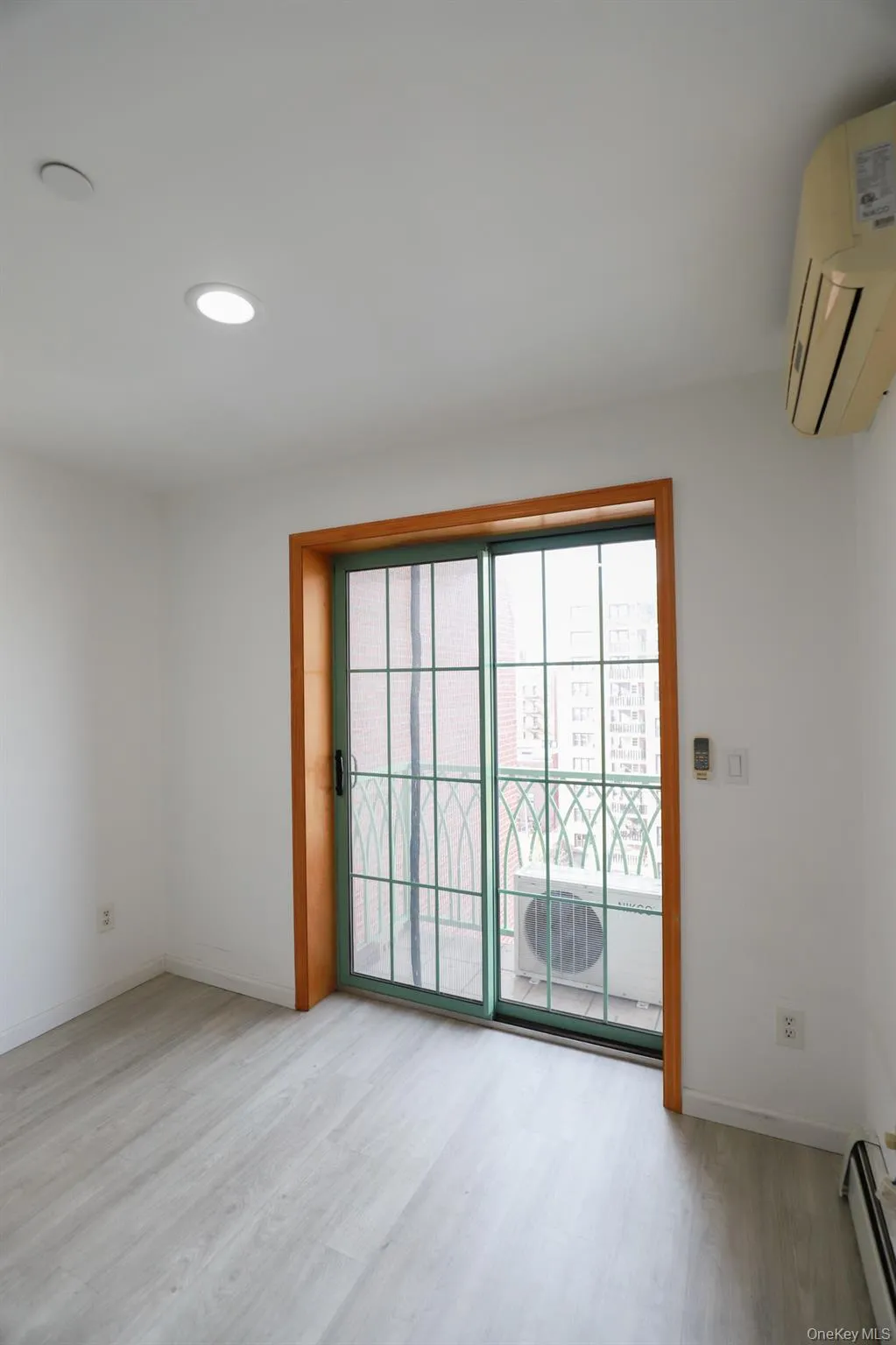 Spare room featuring light wood finished floors, baseboard heating, recessed lighting, and a wall unit AC Spare room featuring light wood finished floors, baseboard heating, recessed lighting, and a wall unit AC