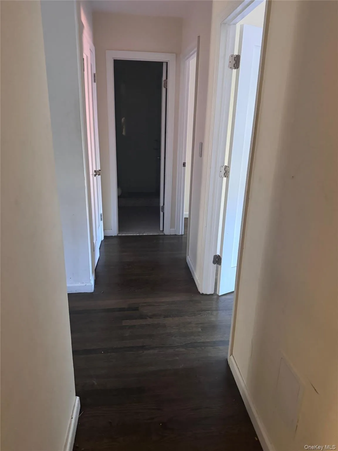 Hall featuring baseboards and dark wood finished floors Hall featuring baseboards and dark wood finished floors