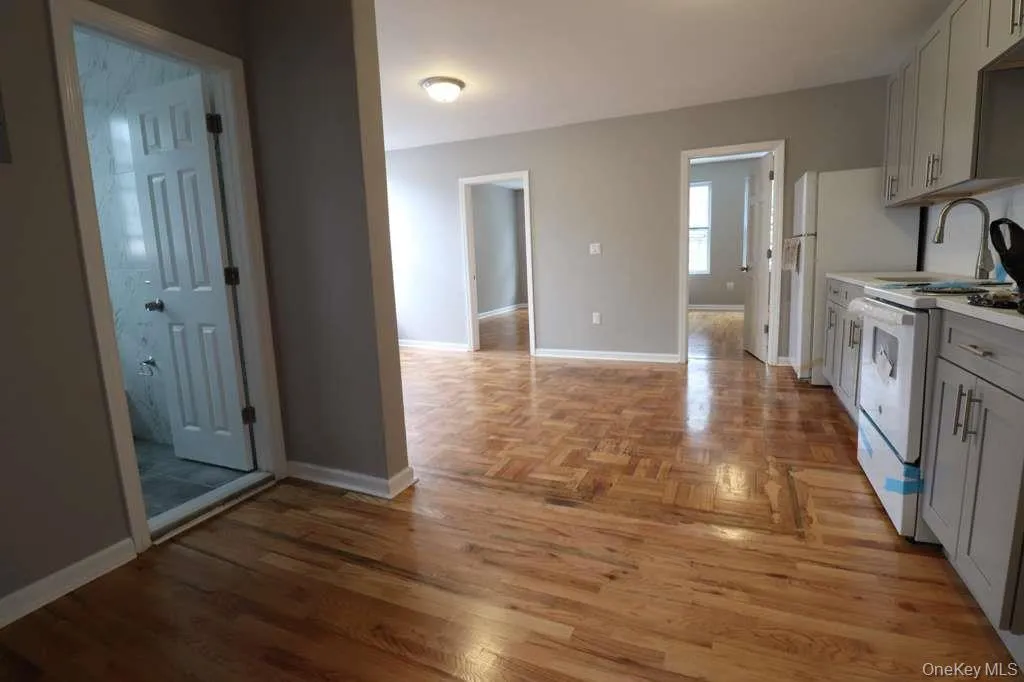 Kitchen with light countertops, electric range, gray cabinetry, and parquet floors Kitchen with light countertops, electric range, gray cabinetry, and parquet floors