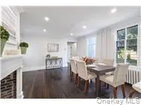 Dining space featuring dark wood finished floors, radiator heating unit, recessed lighting, and a fireplace Dining space featuring dark wood finished floors, radiator heating unit, recessed lighting, and a fireplace