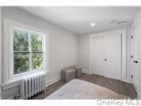 Bedroom with radiator heating unit, dark wood-type flooring, and recessed lighting Bedroom with radiator heating unit, dark wood-type flooring, and recessed lighting