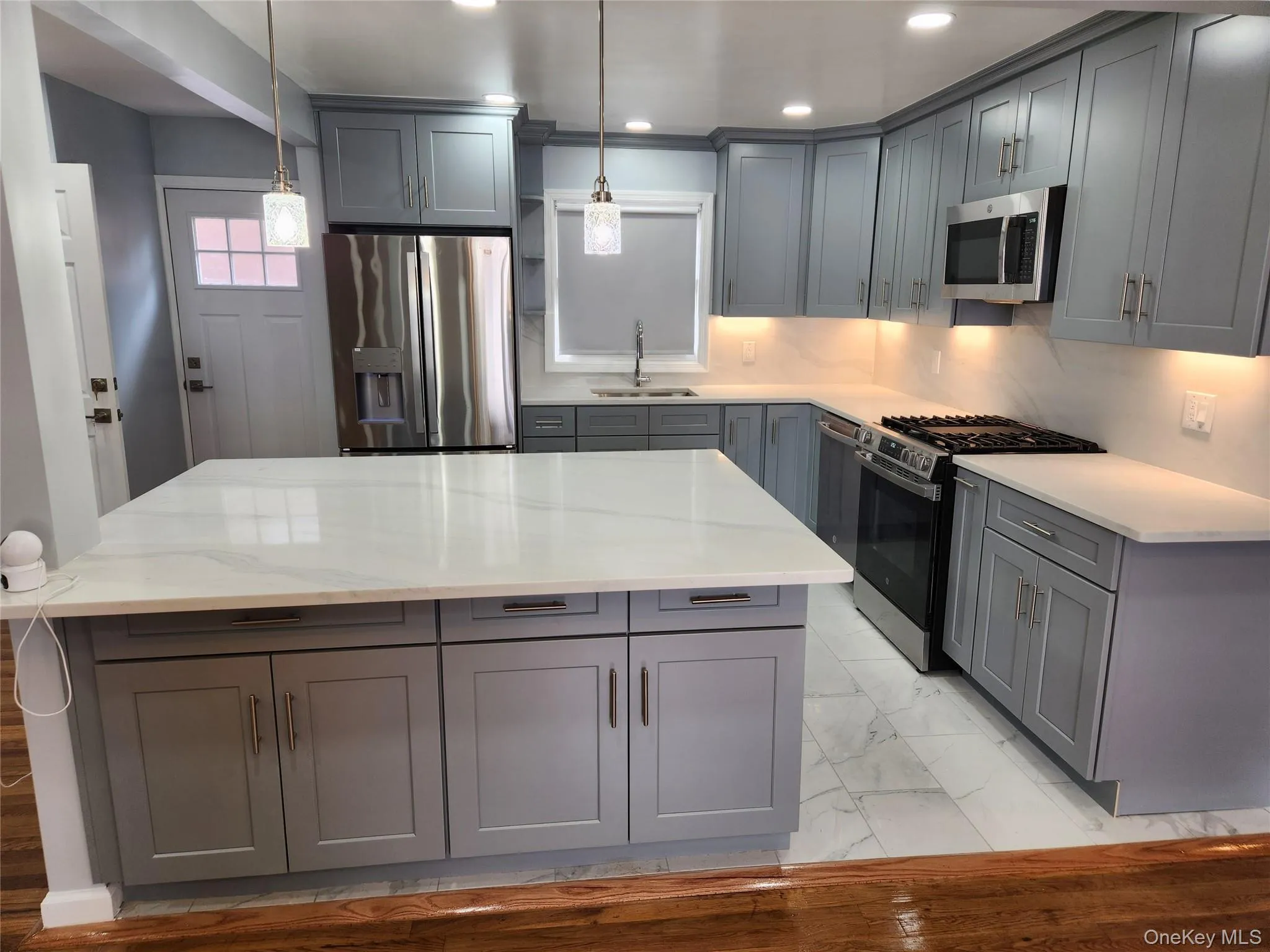 Kitchen with gray cabinets, a sink, and appliances with stainless steel finishes Kitchen with gray cabinets, a sink, and appliances with stainless steel finishes