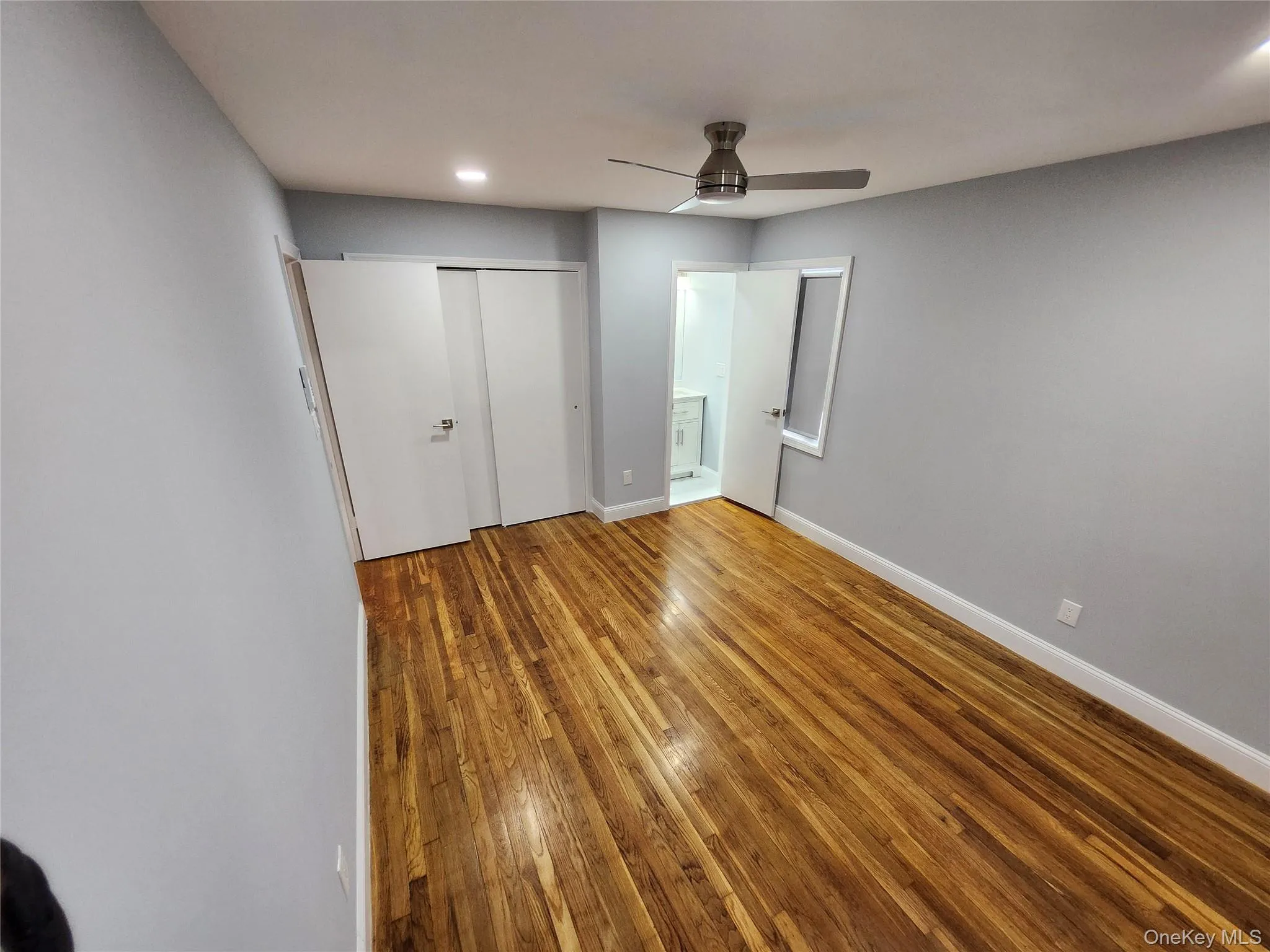 Unfurnished bedroom with a closet, ensuite bathroom, baseboards, and wood finished floors Unfurnished bedroom with a closet, ensuite bathroom, baseboards, and wood finished floors