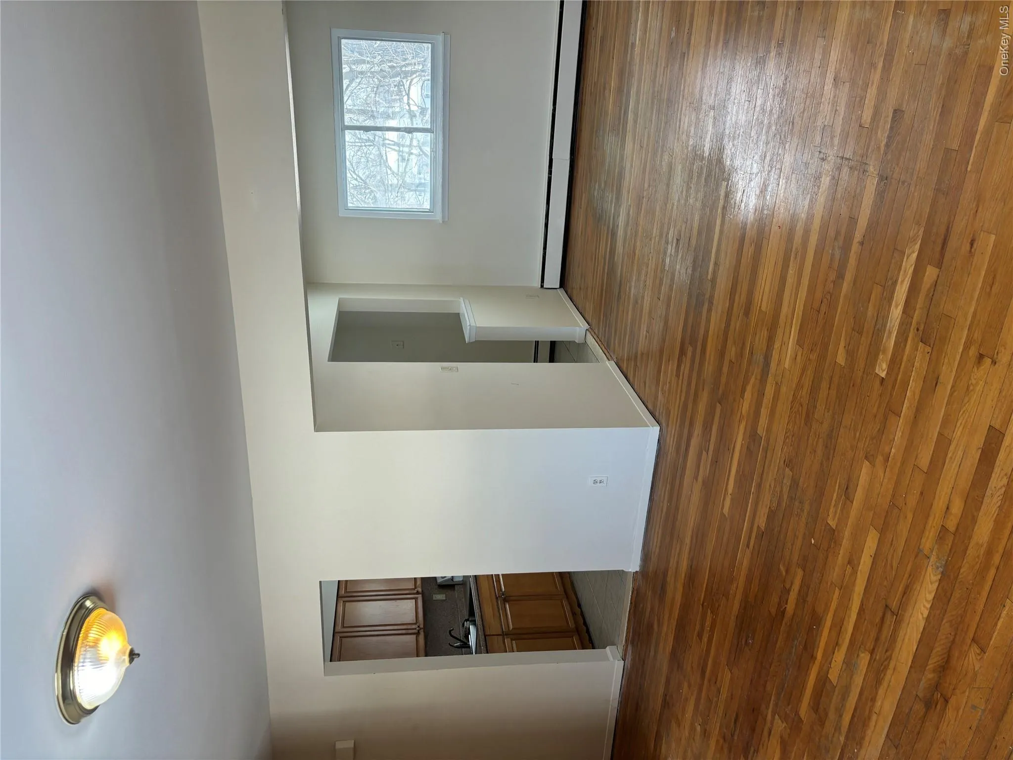 Spare room featuring dark wood-type flooring and a baseboard radiator Spare room featuring dark wood-type flooring and a baseboard radiator