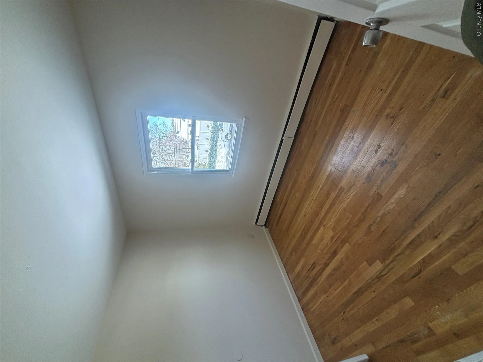 Spare room featuring baseboard heating and dark wood finished floors Spare room featuring baseboard heating and dark wood finished floors