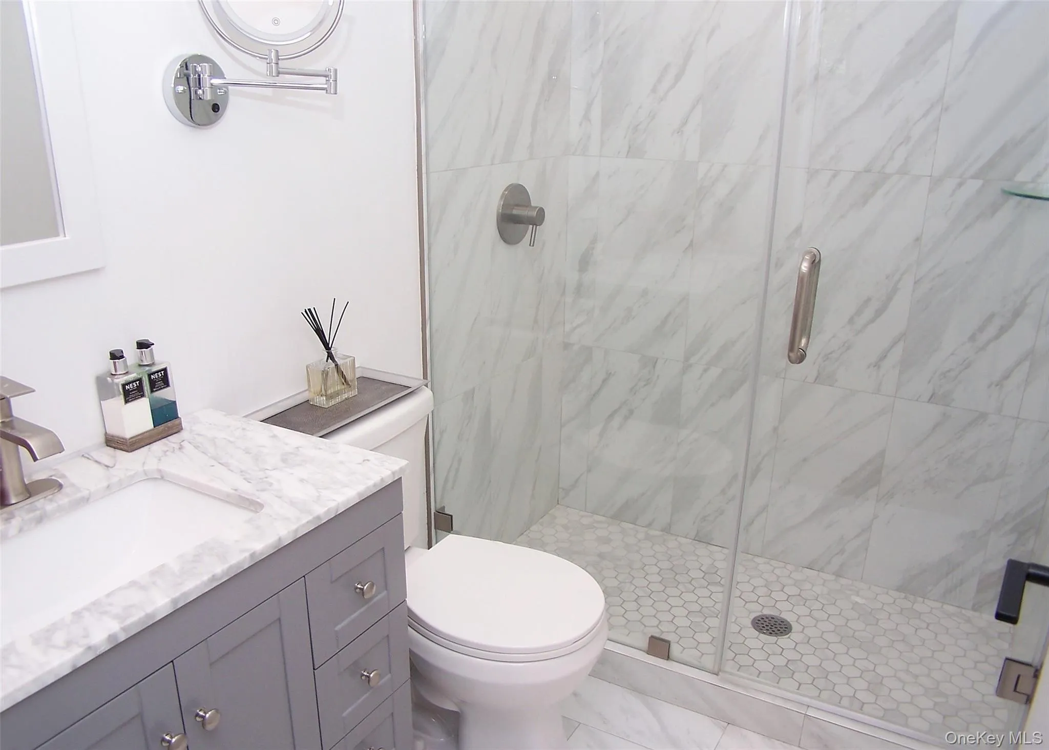 Bathroom featuring a marble finish shower and vanity Bathroom featuring a marble finish shower and vanity