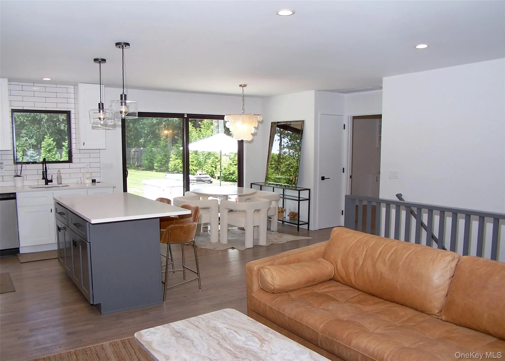 Kitchen with gray cabinetry, decorative backsplash, a breakfast bar area, recessed lighting, and white cabinetry Kitchen with gray cabinetry, decorative backsplash, a breakfast bar area, recessed lighting, and white cabinetry