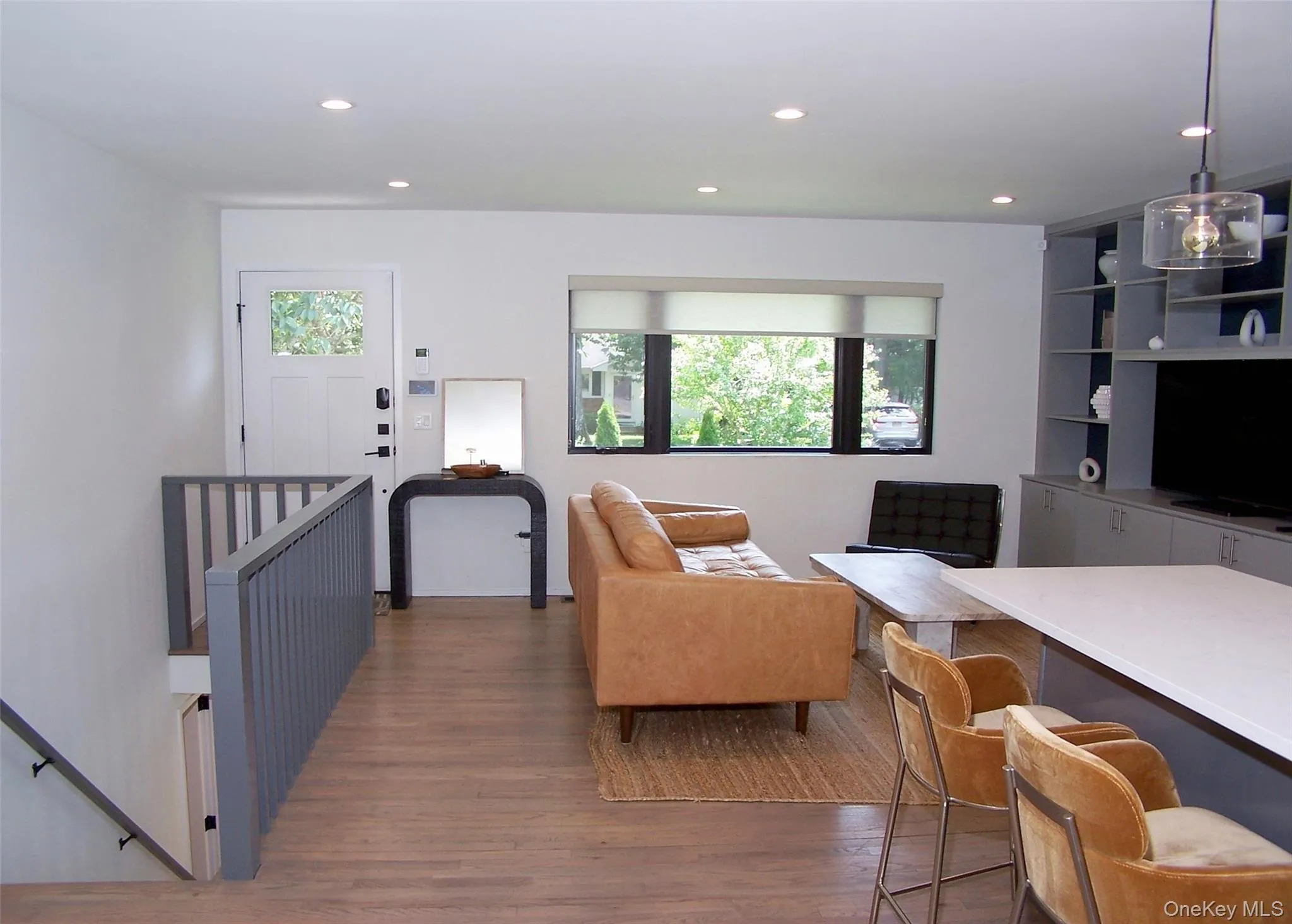 Living area with dark wood finished floors, healthy amount of natural light, and recessed lighting Living area with dark wood finished floors, healthy amount of natural light, and recessed lighting