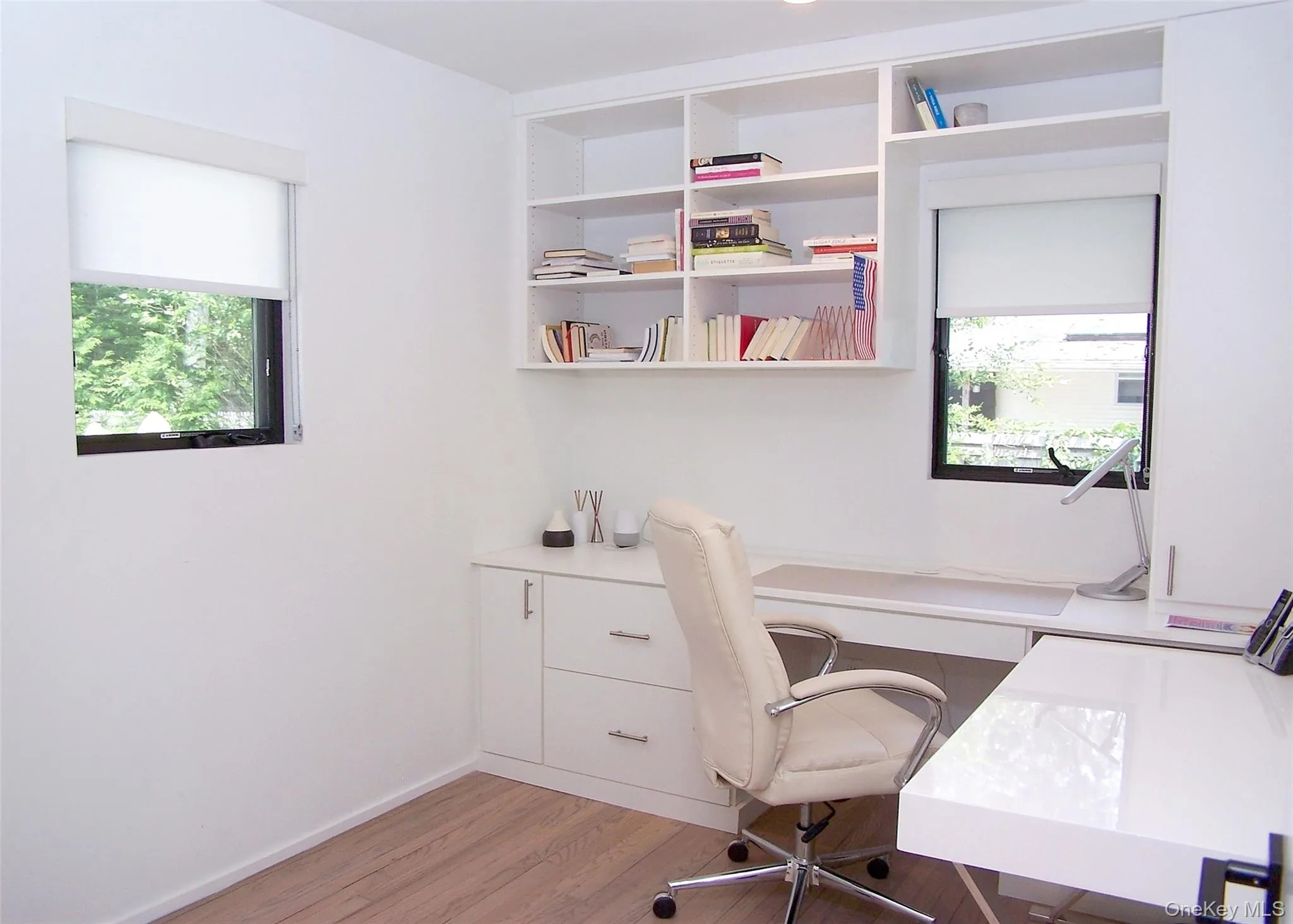 Office space featuring light wood-style floors and built in study area Office space featuring light wood-style floors and built in study area