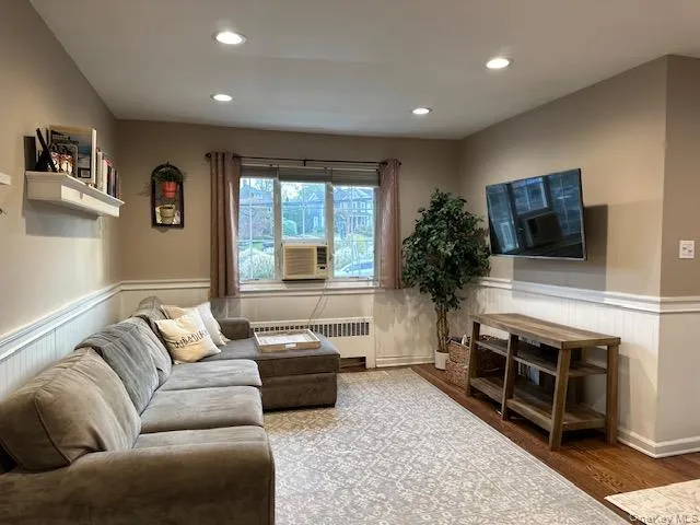 Living area featuring wainscoting, wood floors and recessed lighting Living area featuring wainscoting, wood floors and recessed lighting