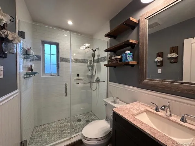 Updated Bathroom with wainscotting, glass shower enclosure and recessed lighting Updated Bathroom with wainscotting, glass shower enclosure and recessed lighting
