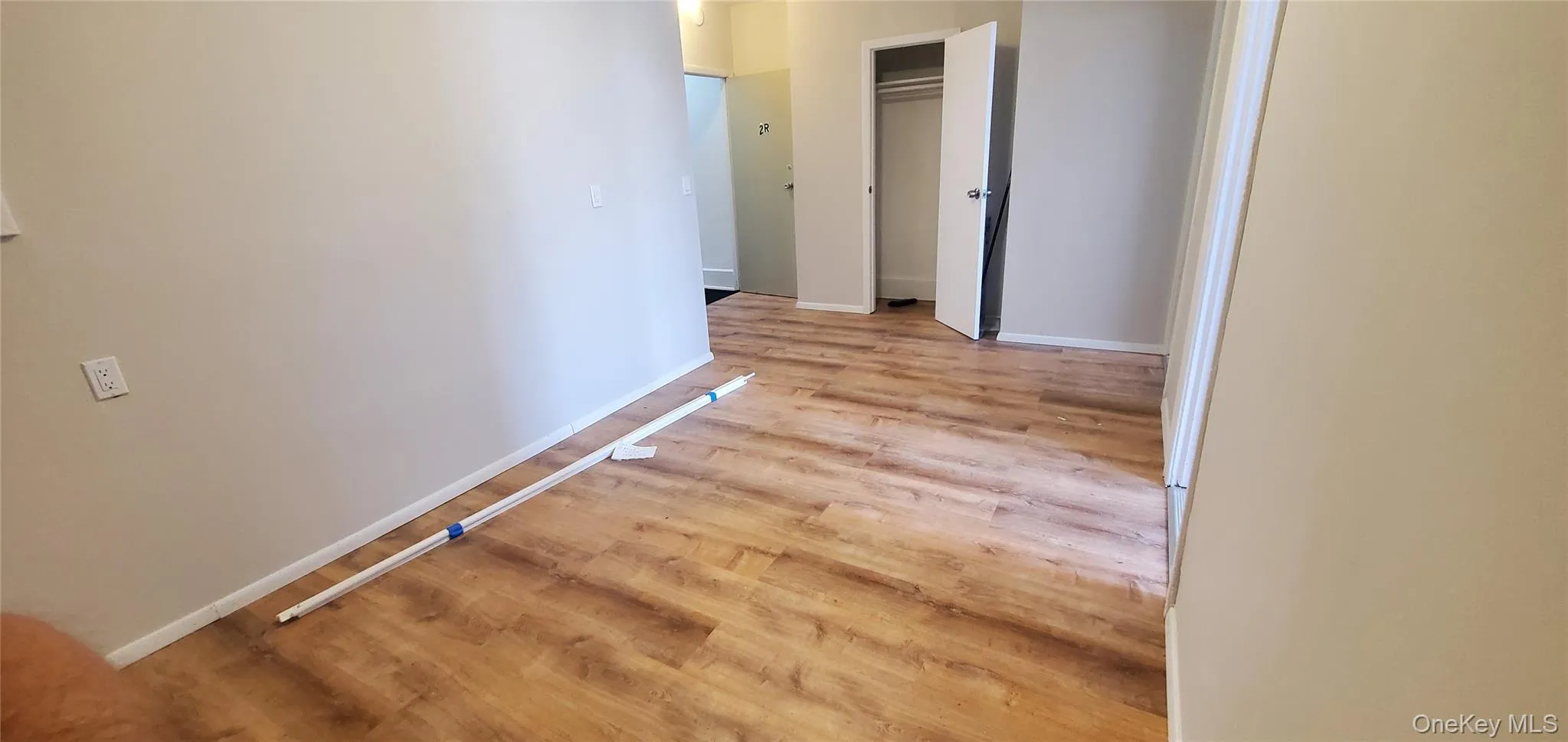Hallway featuring baseboards and light wood-type flooring Hallway featuring baseboards and light wood-type flooring