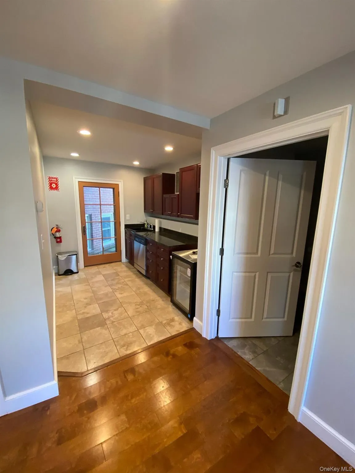 Kitchen with dark countertops, light wood-style flooring, recessed lighting, dark brown cabinetry, and dishwasher Kitchen with dark countertops, light wood-style flooring, recessed lighting, dark brown cabinetry, and dishwasher