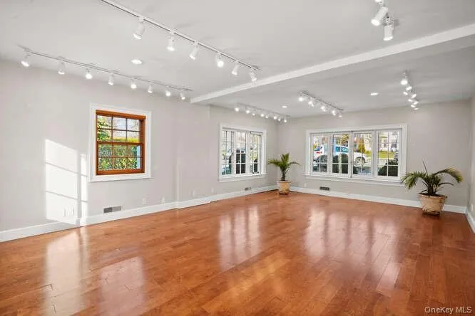 Unfurnished living room with wood finished floors and rail lighting Unfurnished living room with wood finished floors and rail lighting