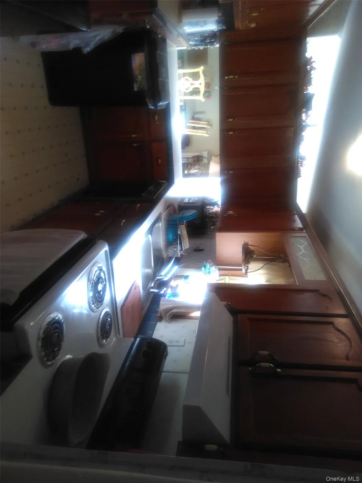 Kitchen featuring white range, range hood, light floors, dishwashing machine, and light countertops Kitchen featuring white range, range hood, light floors, dishwashing machine, and light countertops