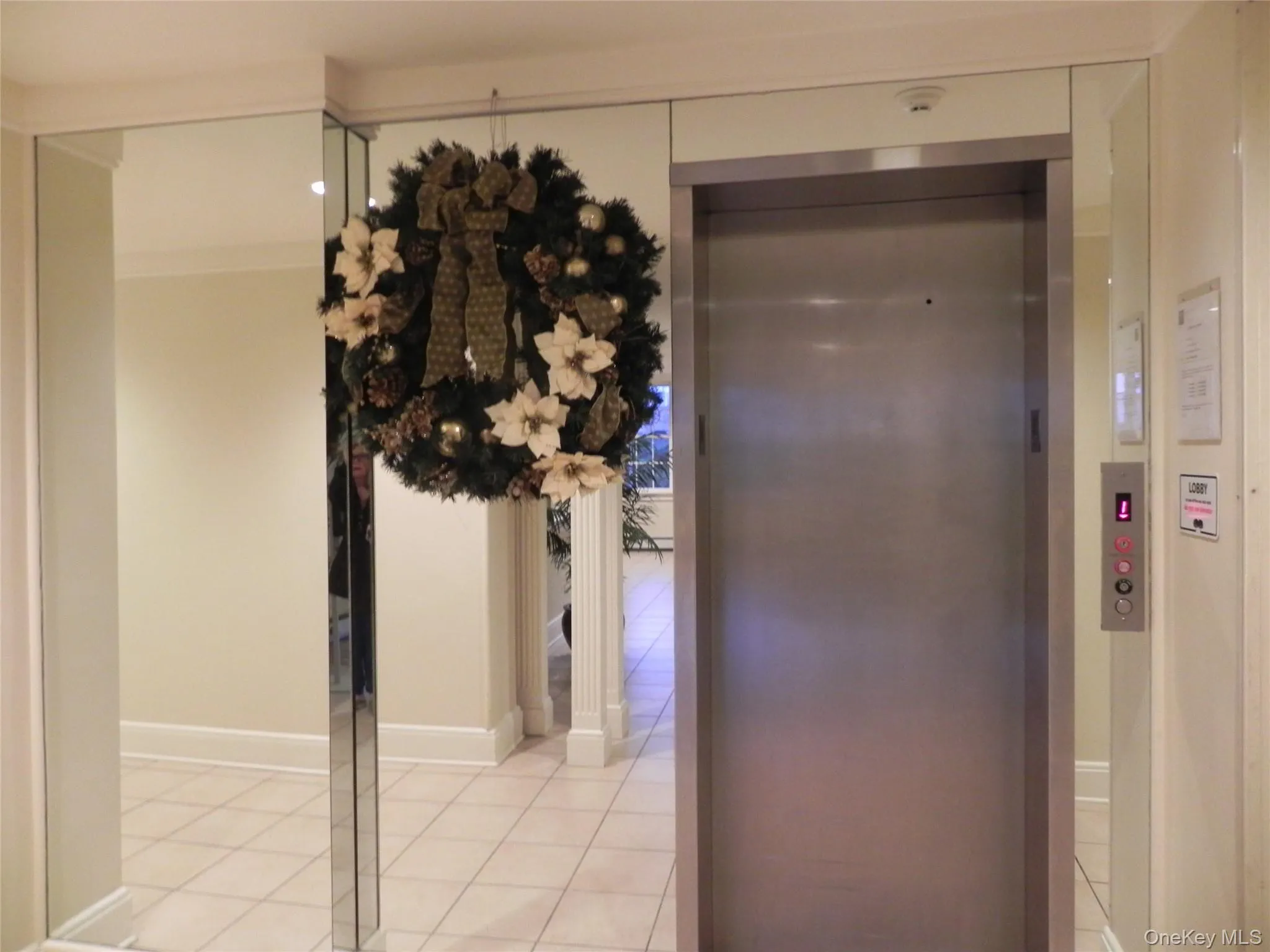 Corridor with light tile patterned floors and elevator Corridor with light tile patterned floors and elevator