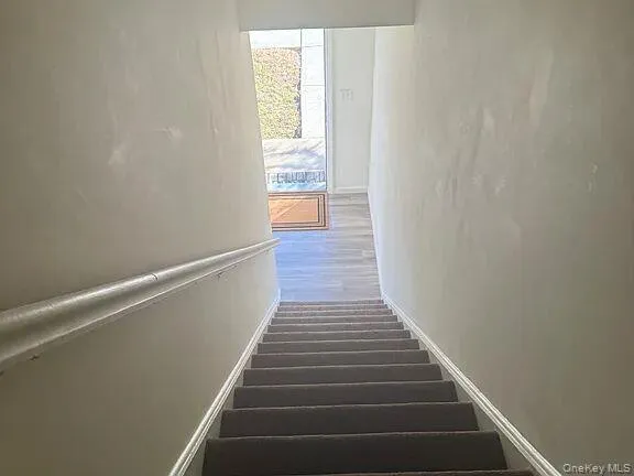 Stairs featuring baseboards and wood finished floors Stairs featuring baseboards and wood finished floors