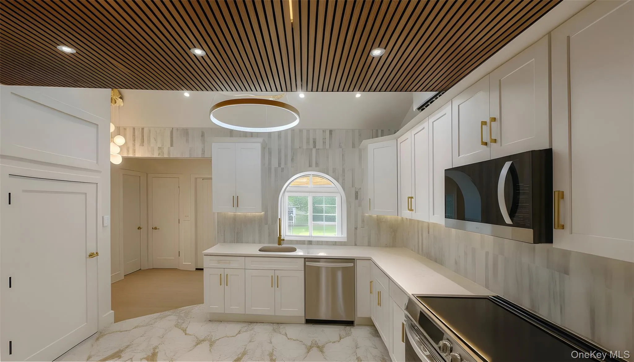 Kitchen with appliances with stainless steel finishes, white cabinets, recessed lighting, tasteful backsplash, and light stone countertops Kitchen with appliances with stainless steel finishes, white cabinets, recessed lighting, tasteful backsplash, and light stone countertops