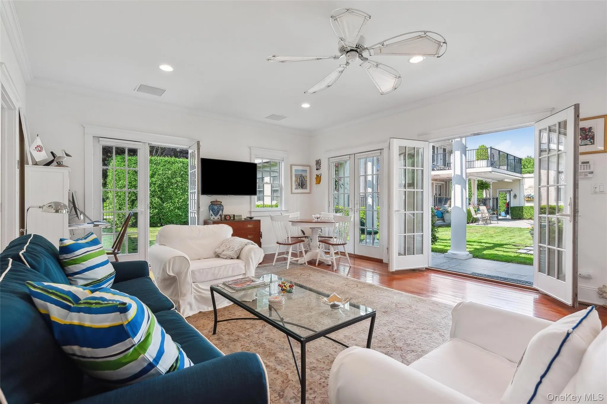 Living area with ornamental molding, french doors, wood finished floors, recessed lighting, and ceiling fan Living area with ornamental molding, french doors, wood finished floors, recessed lighting, and ceiling fan