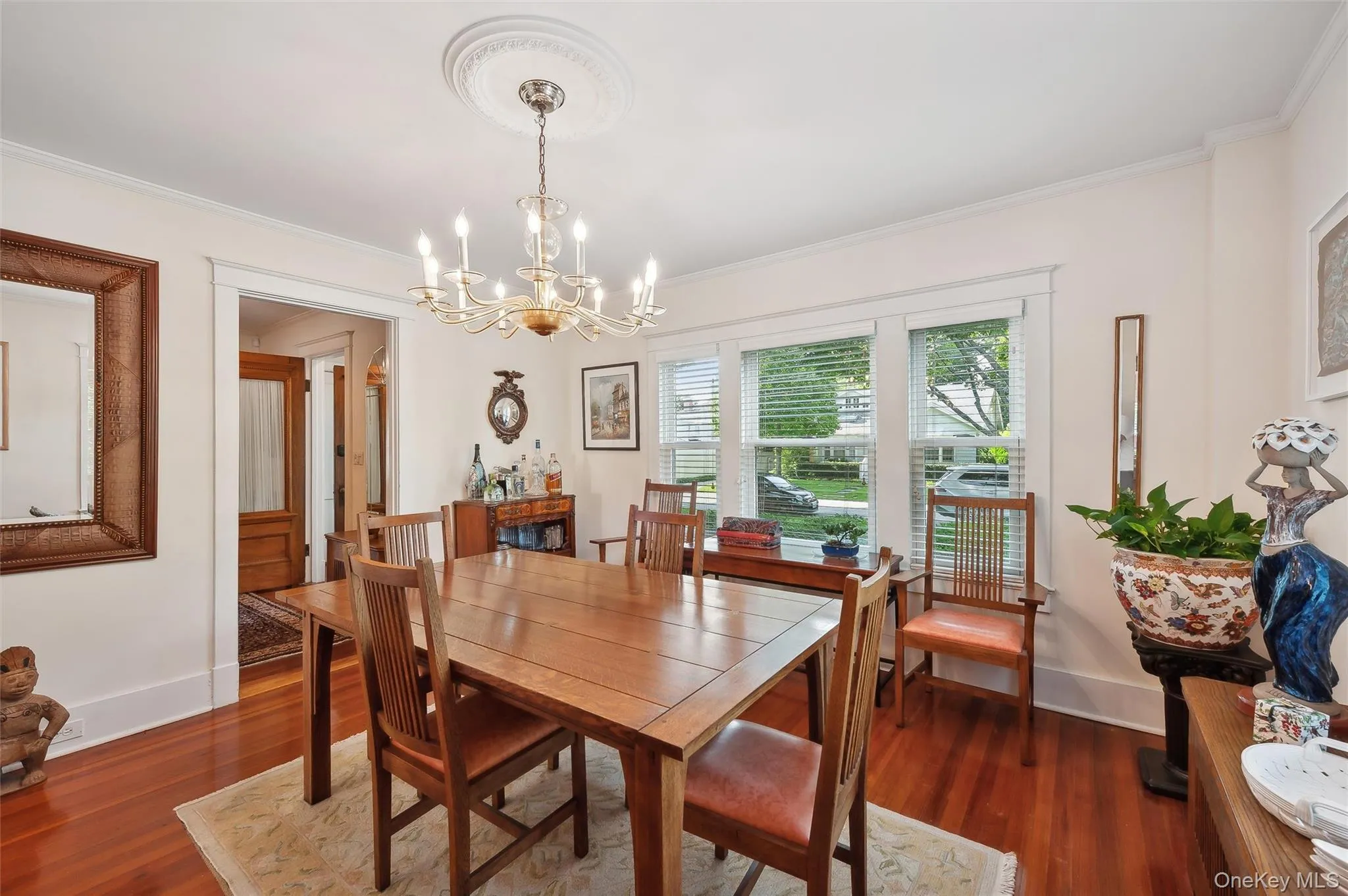 Dining area featuring dark wood-style floors, a chandelier, and crown molding Dining area featuring dark wood-style floors, a chandelier, and crown molding