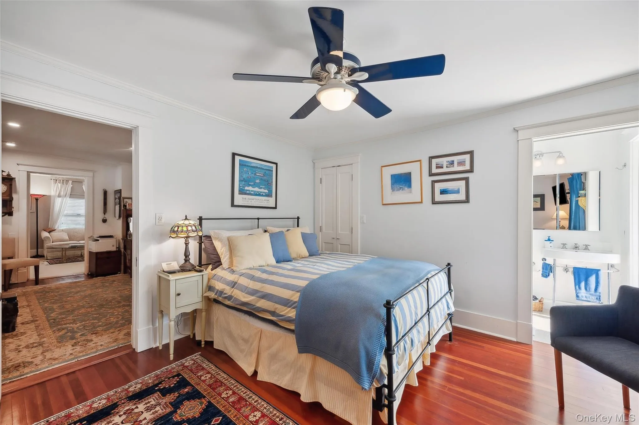 Bedroom with wood finished floors, a closet, crown molding, ceiling fan, and connected bathroom Bedroom with wood finished floors, a closet, crown molding, ceiling fan, and connected bathroom