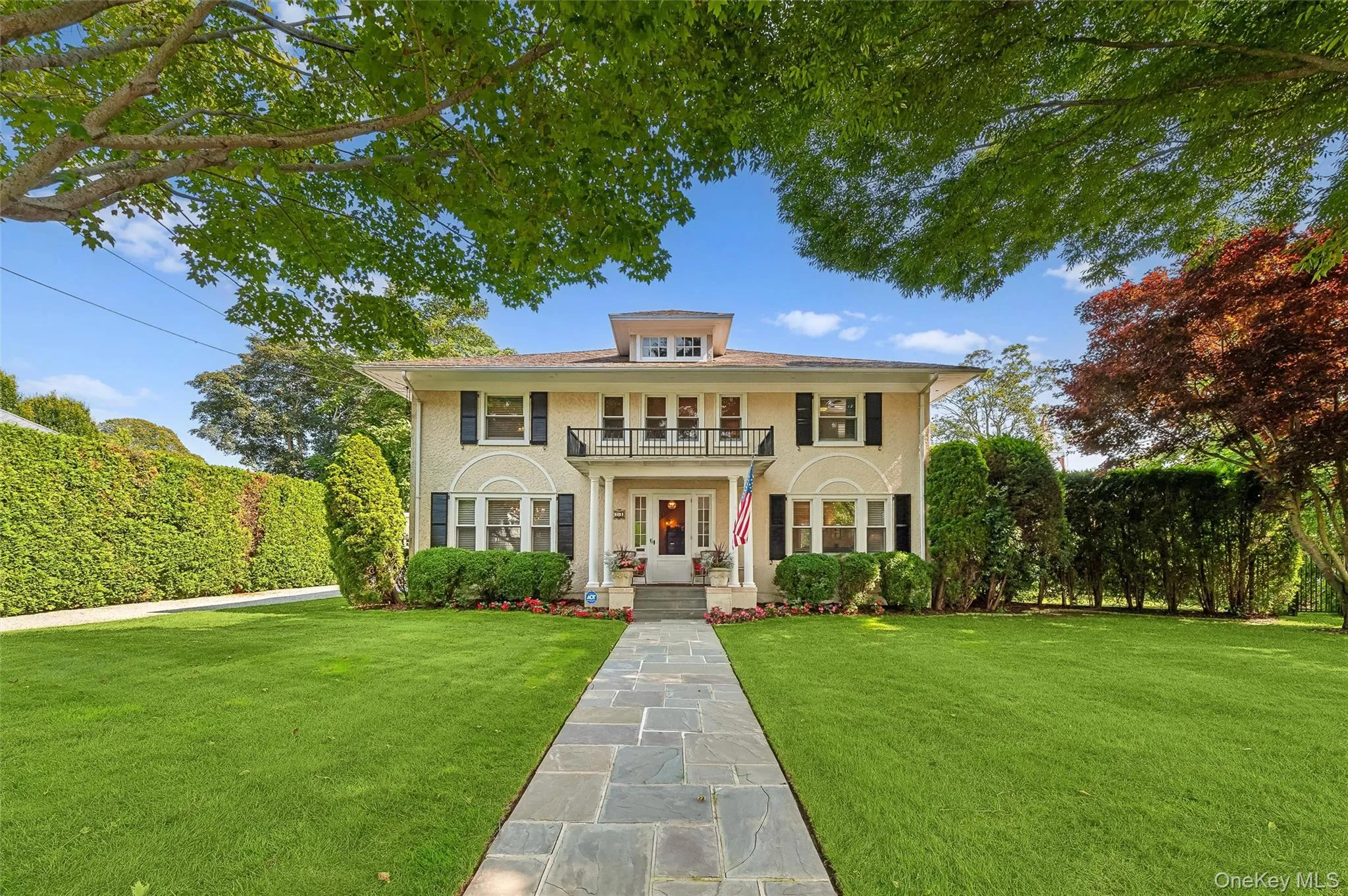 View of front of home featuring a front yard and a balcony View of front of home featuring a front yard and a balcony