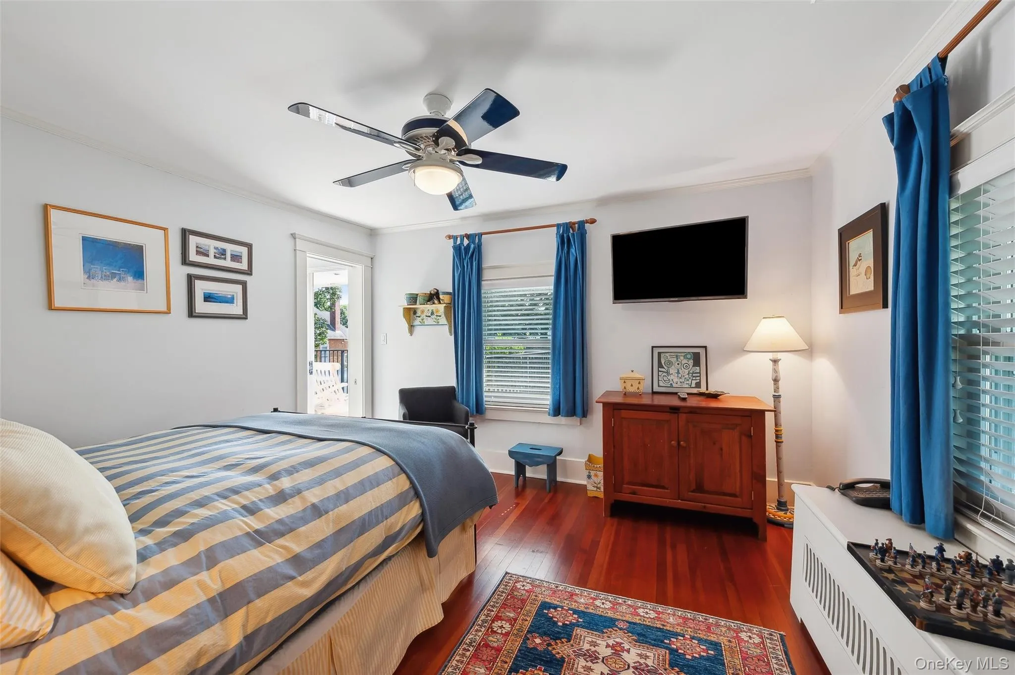 Bedroom with access to exterior, dark wood-style flooring, crown molding, and ceiling fan Bedroom with access to exterior, dark wood-style flooring, crown molding, and ceiling fan