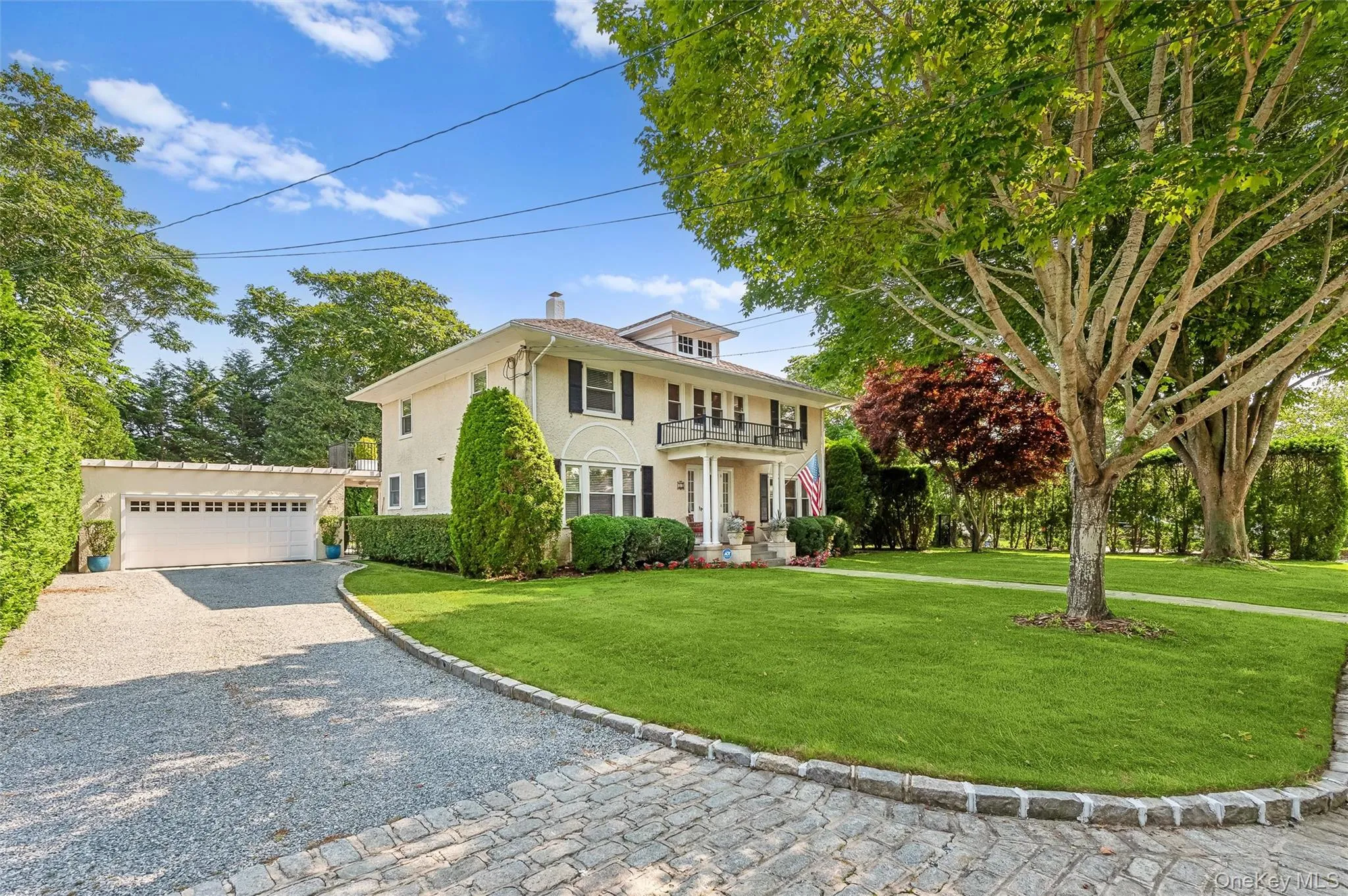 View of front facade featuring a front lawn, stucco siding, a chimney, and a balcony View of front facade featuring a front lawn, stucco siding, a chimney, and a balcony