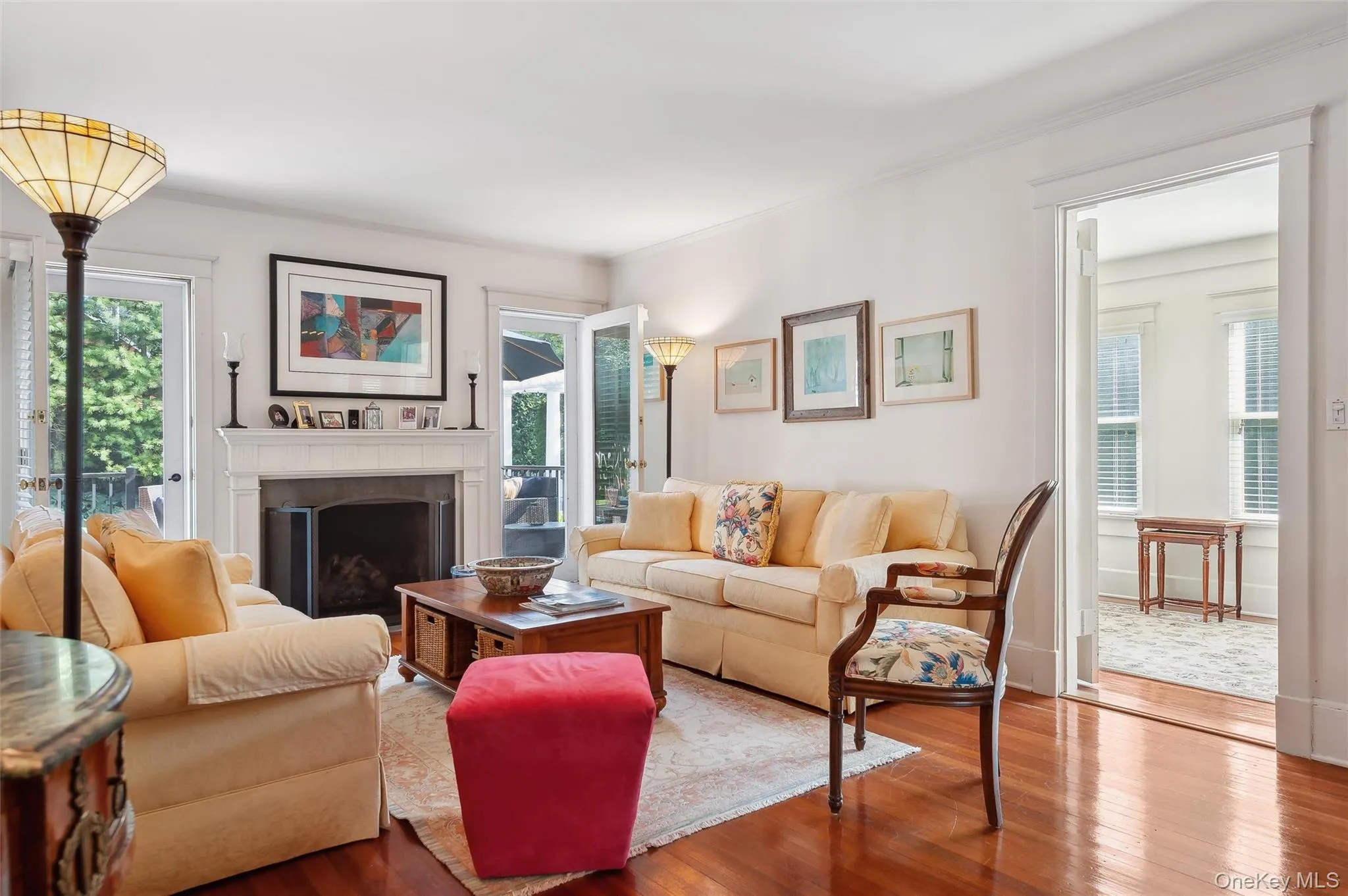 Living room with wood finished floors, a fireplace, and crown molding Living room with wood finished floors, a fireplace, and crown molding