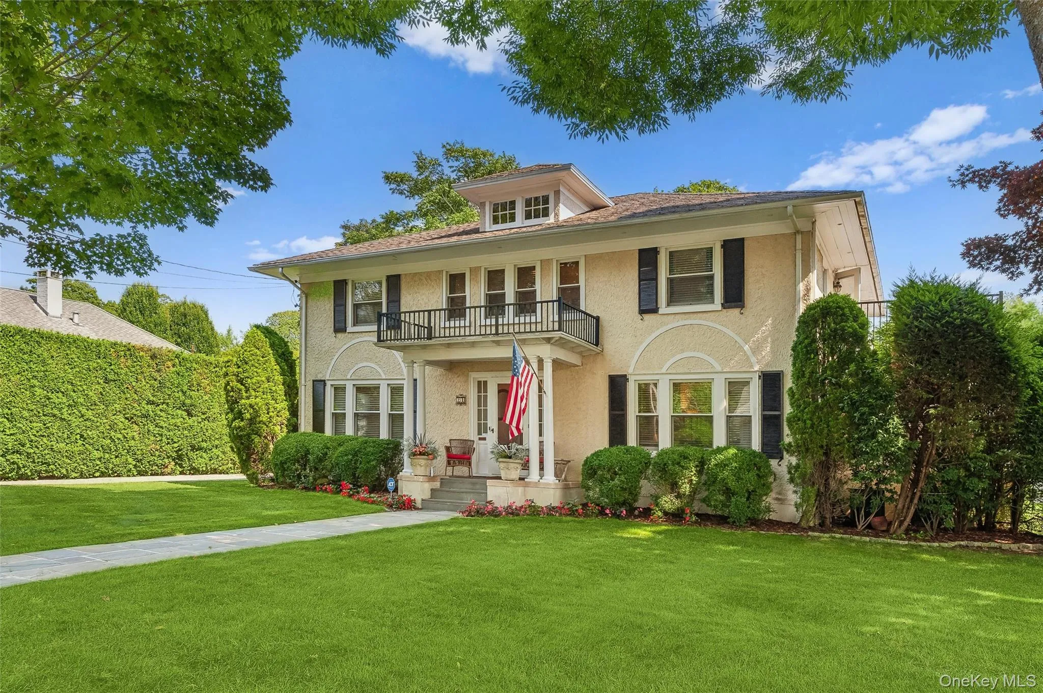 View of front facade featuring a front yard, a balcony, and stucco siding View of front facade featuring a front yard, a balcony, and stucco siding