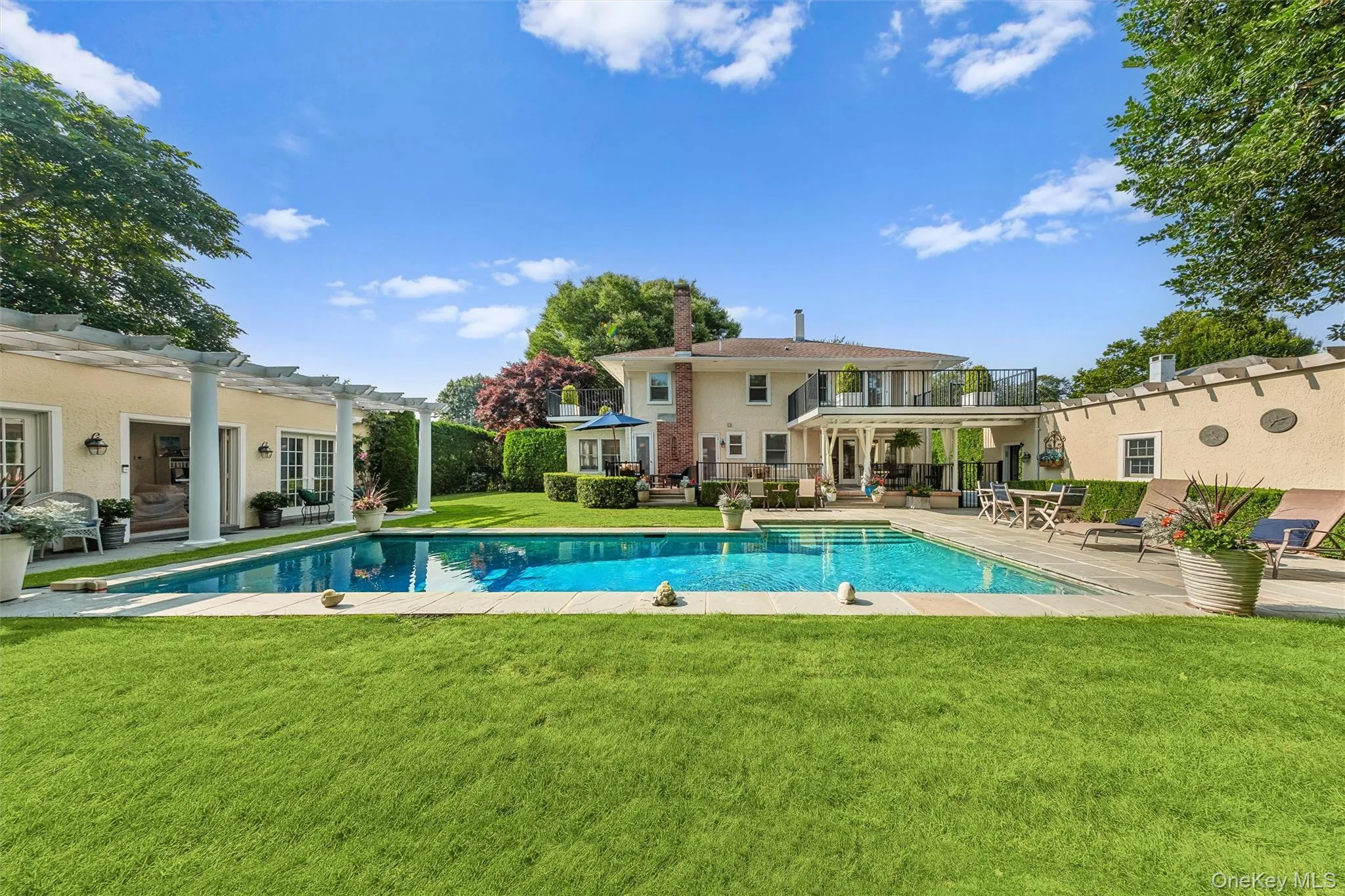 Swimming pool featuring a patio, a pergola, a lawn, a balcony, and an outdoor living space Swimming pool featuring a patio, a pergola, a lawn, a balcony, and an outdoor living space
