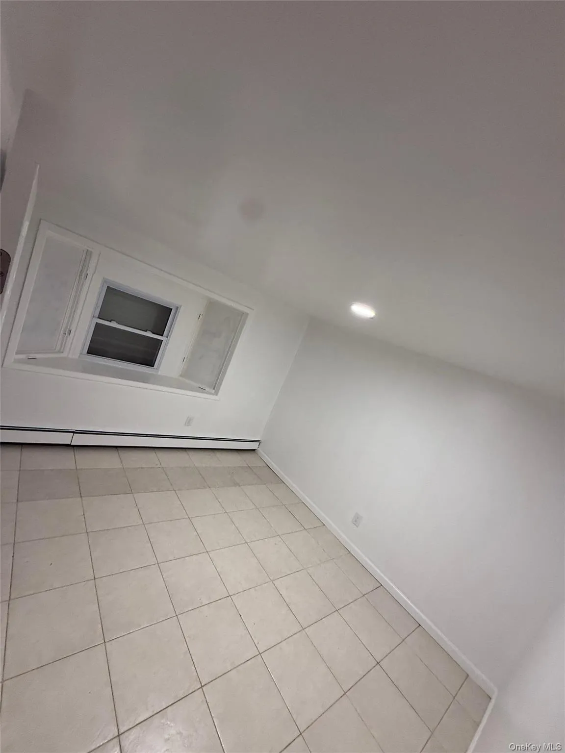 Additional living space featuring light tile patterned floors, a baseboard radiator, and recessed lighting Additional living space featuring light tile patterned floors, a baseboard radiator, and recessed lighting
