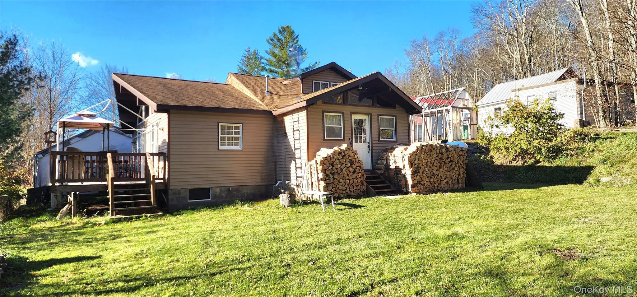 Back of house with a yard, roof with shingles, a gazebo, and a wooden deck Back of house with a yard, roof with shingles, a gazebo, and a wooden deck