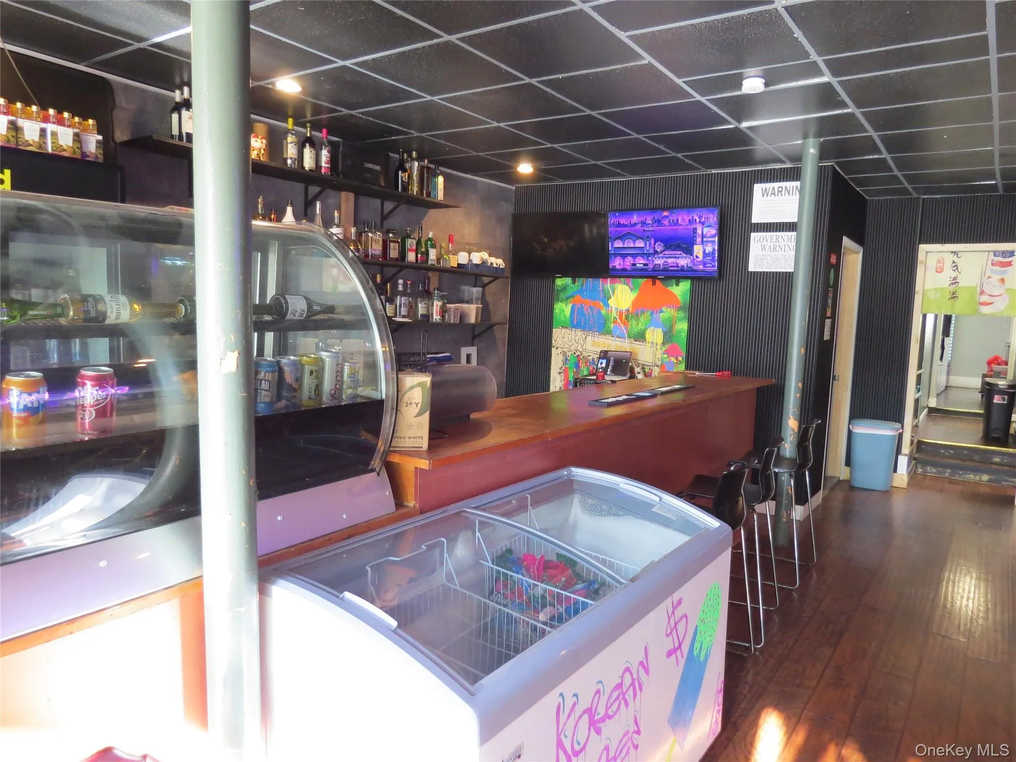 Bar area featuring open shelves, a paneled ceiling, and wooden counters Bar area featuring open shelves, a paneled ceiling, and wooden counters
