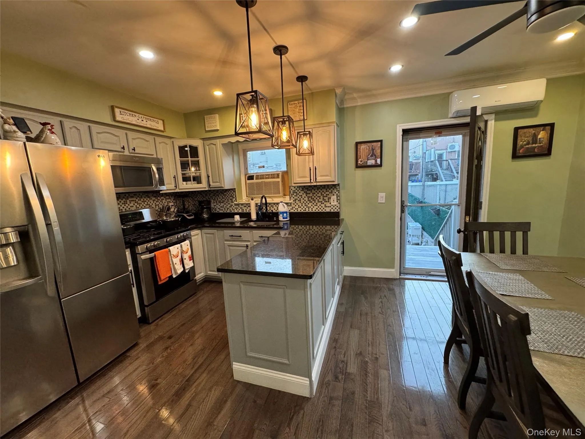 Kitchen with stainless steel appliances, dark wood-style flooring, hanging light fixtures, a peninsula, and recessed lighting Kitchen with stainless steel appliances, dark wood-style flooring, hanging light fixtures, a peninsula, and recessed lighting