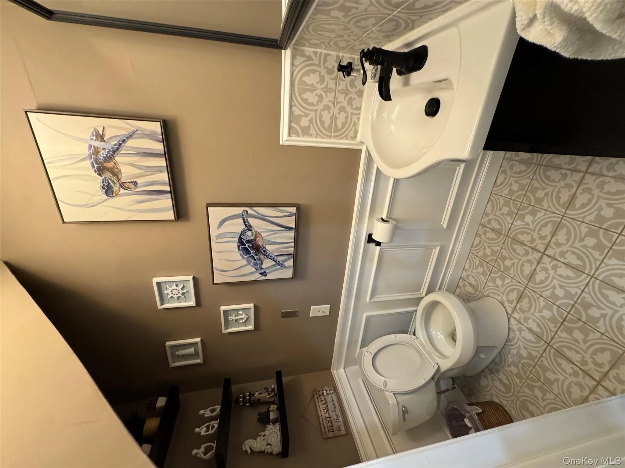 Bathroom with a wainscoted wall, vanity, light tile patterned floors, and a decorative wall Bathroom with a wainscoted wall, vanity, light tile patterned floors, and a decorative wall