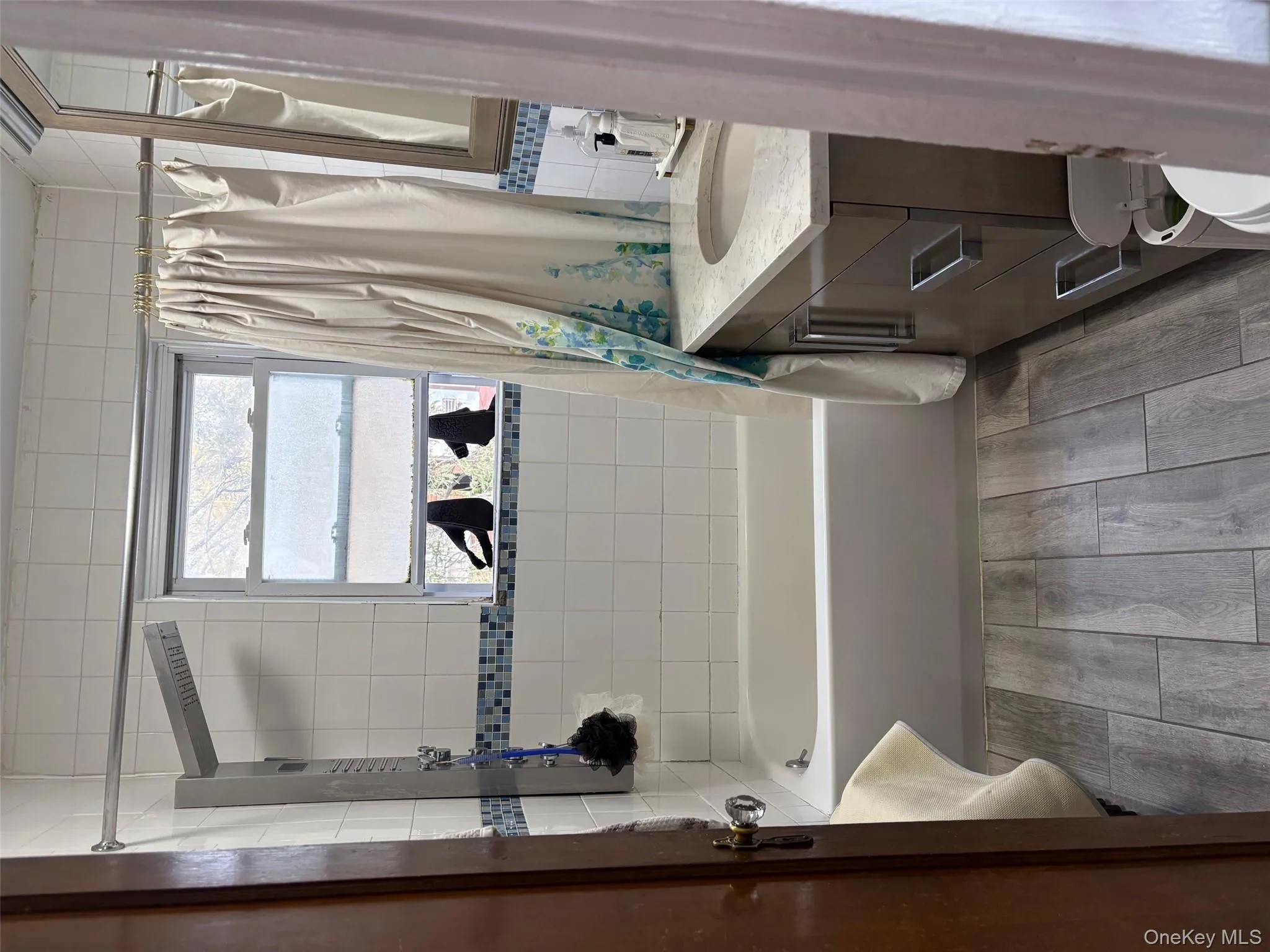 Bathroom featuring shower / bath combo, vanity, and light wood finished floors Bathroom featuring shower / bath combo, vanity, and light wood finished floors
