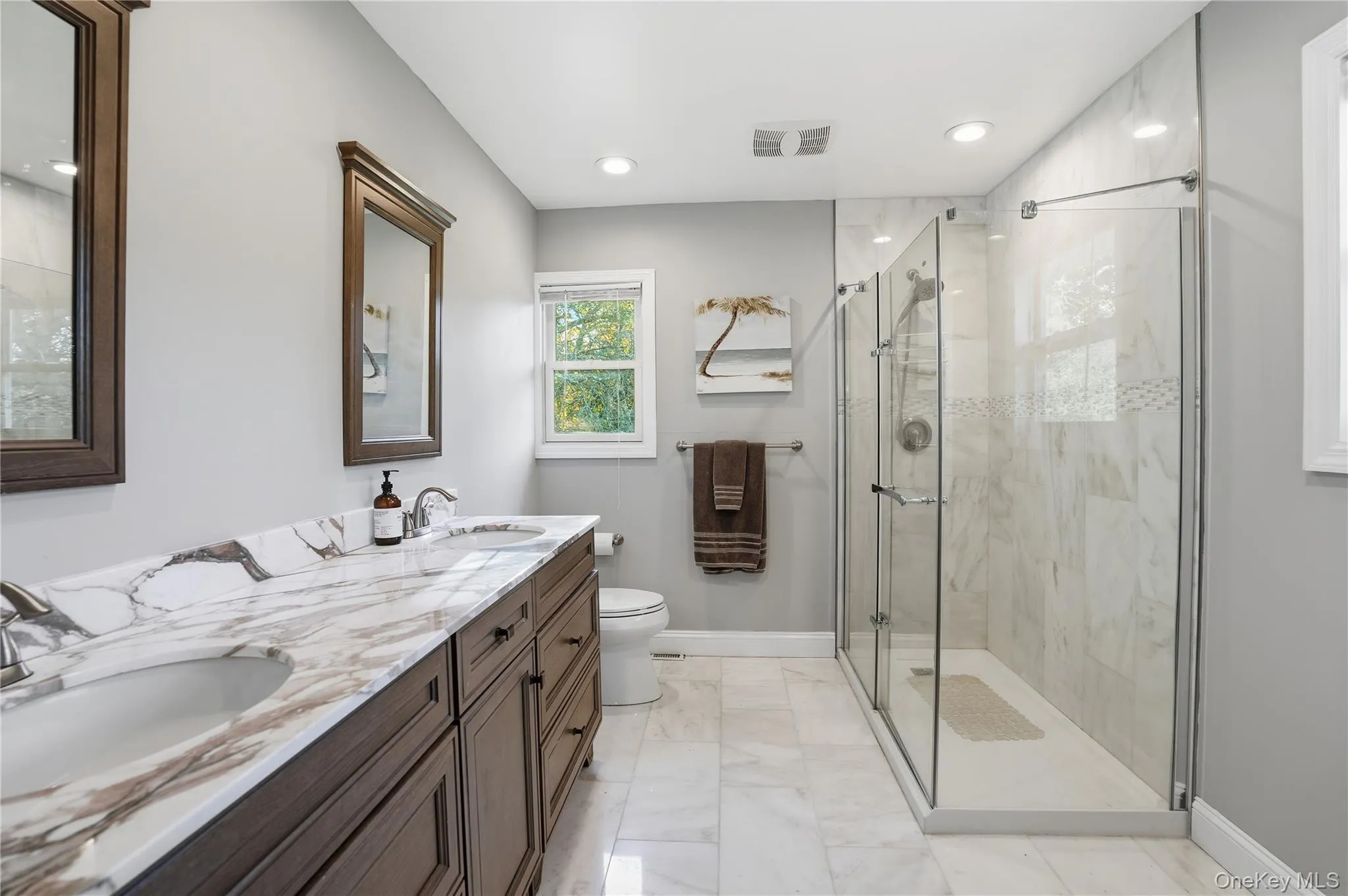 Bathroom featuring a marble finish shower, light marble finish flooring, double vanity, and recessed lighting Bathroom featuring a marble finish shower, light marble finish flooring, double vanity, and recessed lighting