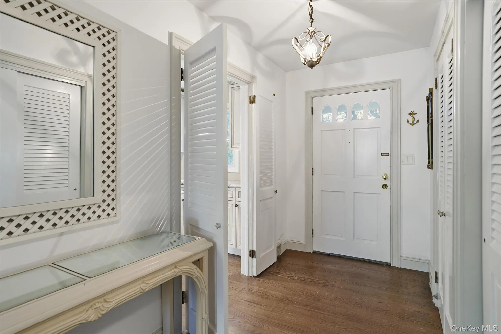 Entryway featuring dark wood-style flooring and a chandelier Entryway featuring dark wood-style flooring and a chandelier