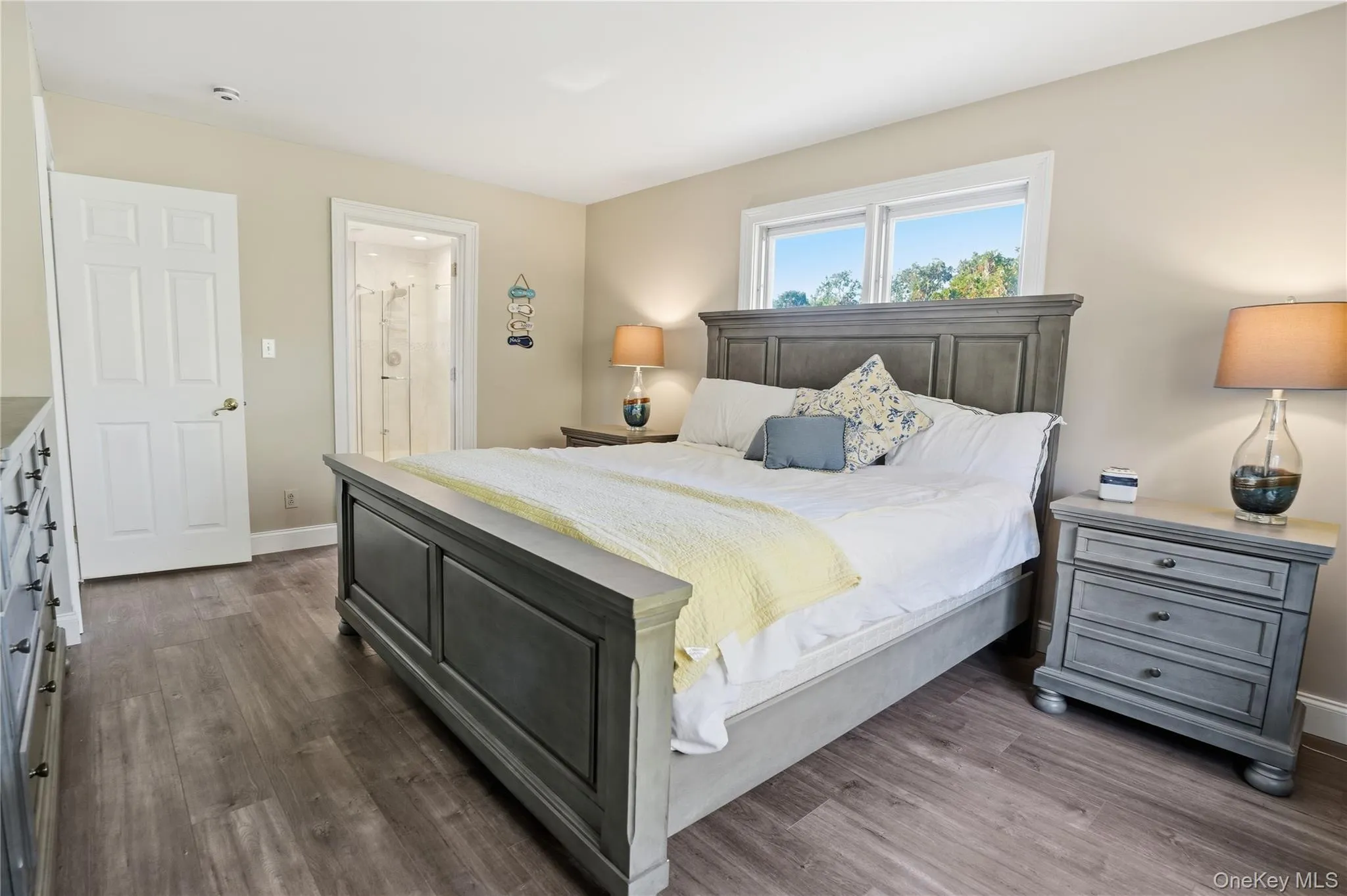 Bedroom featuring dark wood-style floors and ensuite bath Bedroom featuring dark wood-style floors and ensuite bath