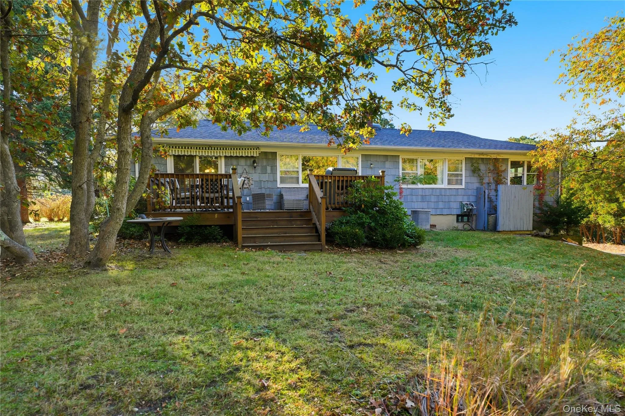 Rear view of house featuring a yard, a shingled roof, a deck, and crawl space Rear view of house featuring a yard, a shingled roof, a deck, and crawl space
