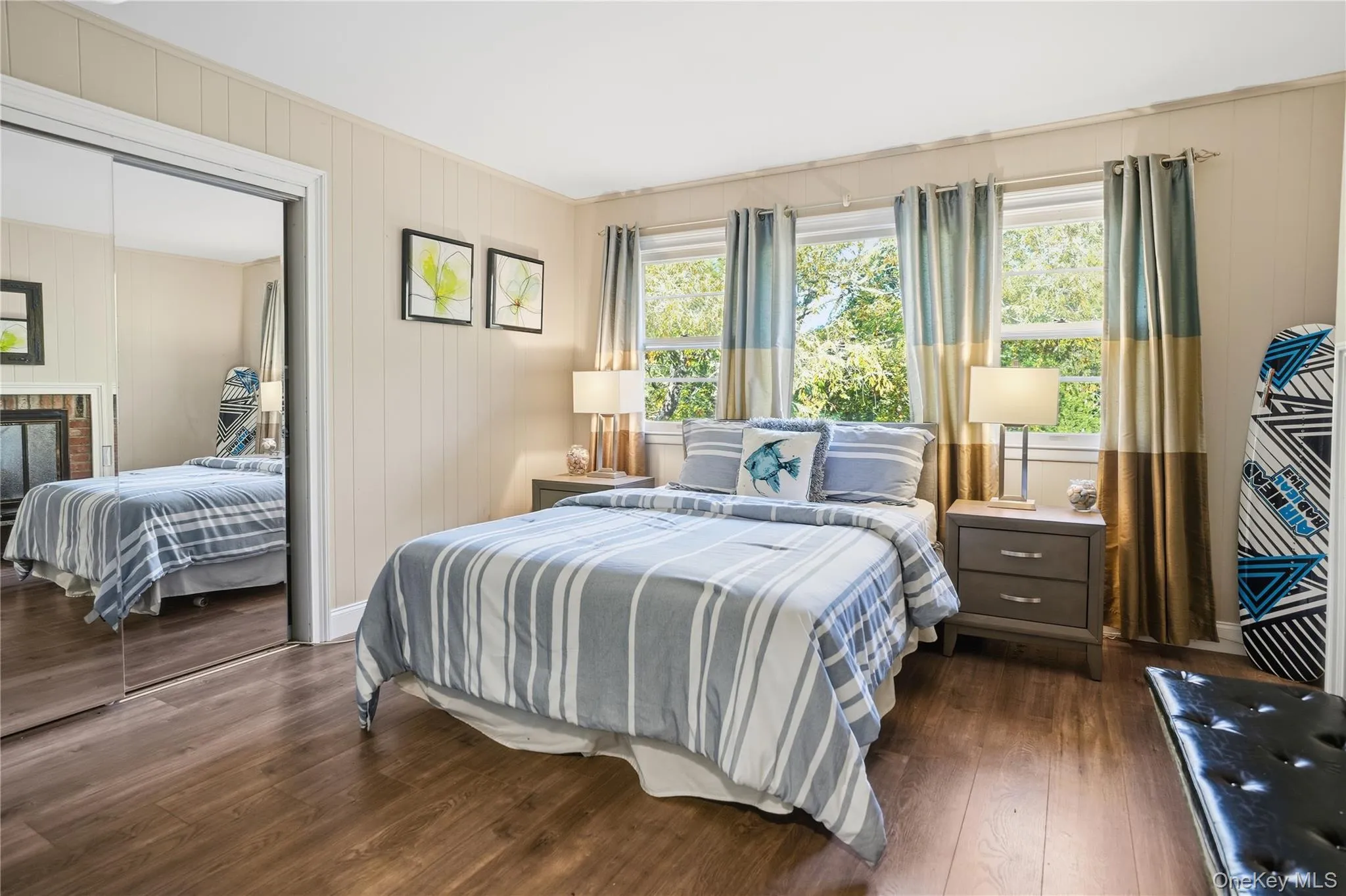 Bedroom featuring dark wood finished floors, wooden walls, and a closet Bedroom featuring dark wood finished floors, wooden walls, and a closet