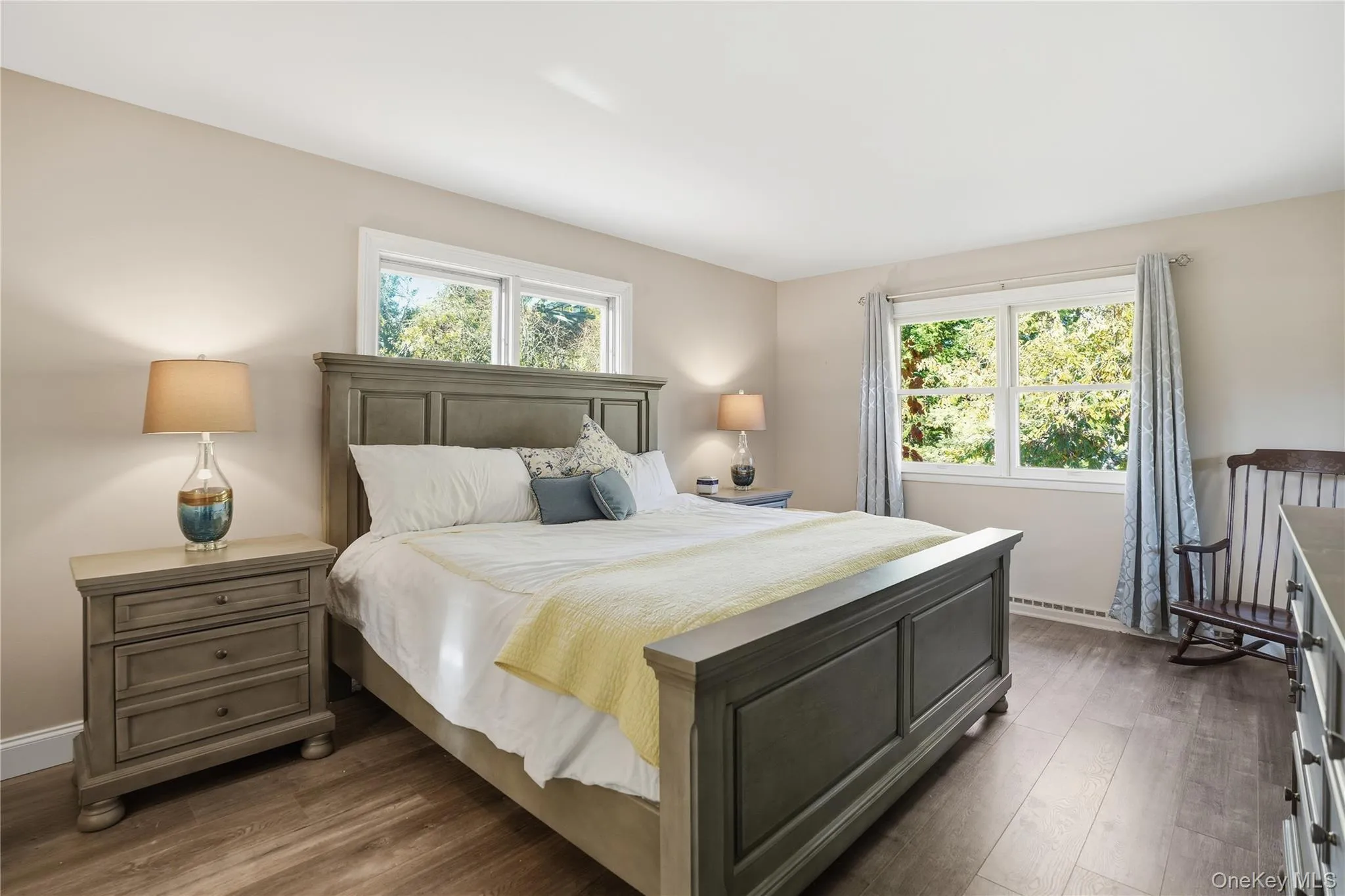 Bedroom featuring multiple windows and dark wood finished floors Bedroom featuring multiple windows and dark wood finished floors