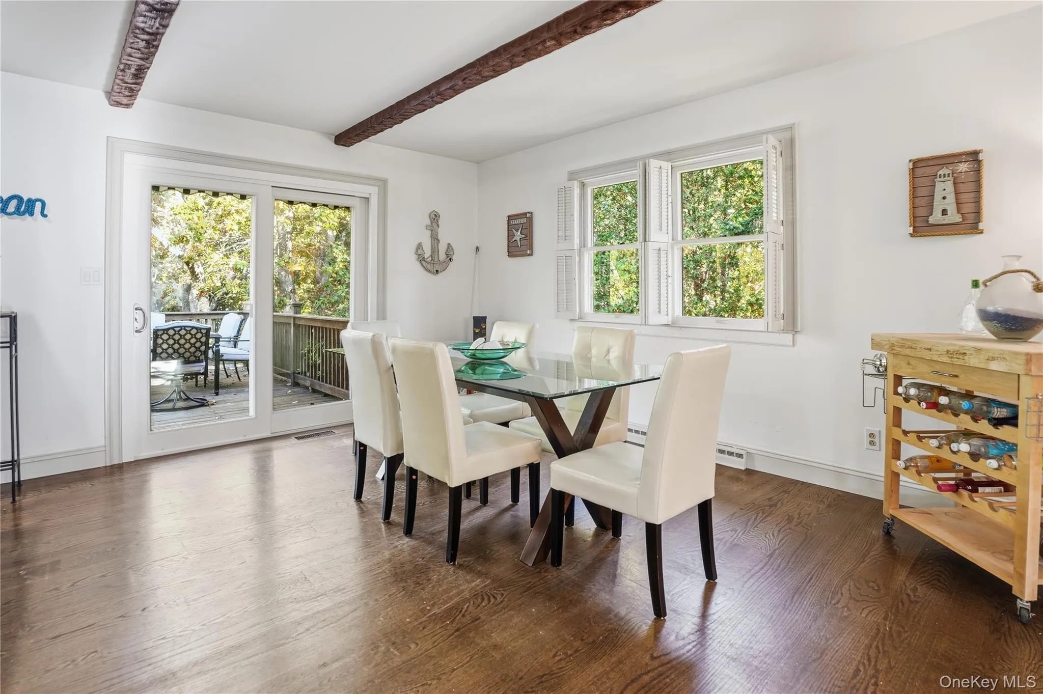 Dining room with dark wood-type flooring and beam ceiling Dining room with dark wood-type flooring and beam ceiling