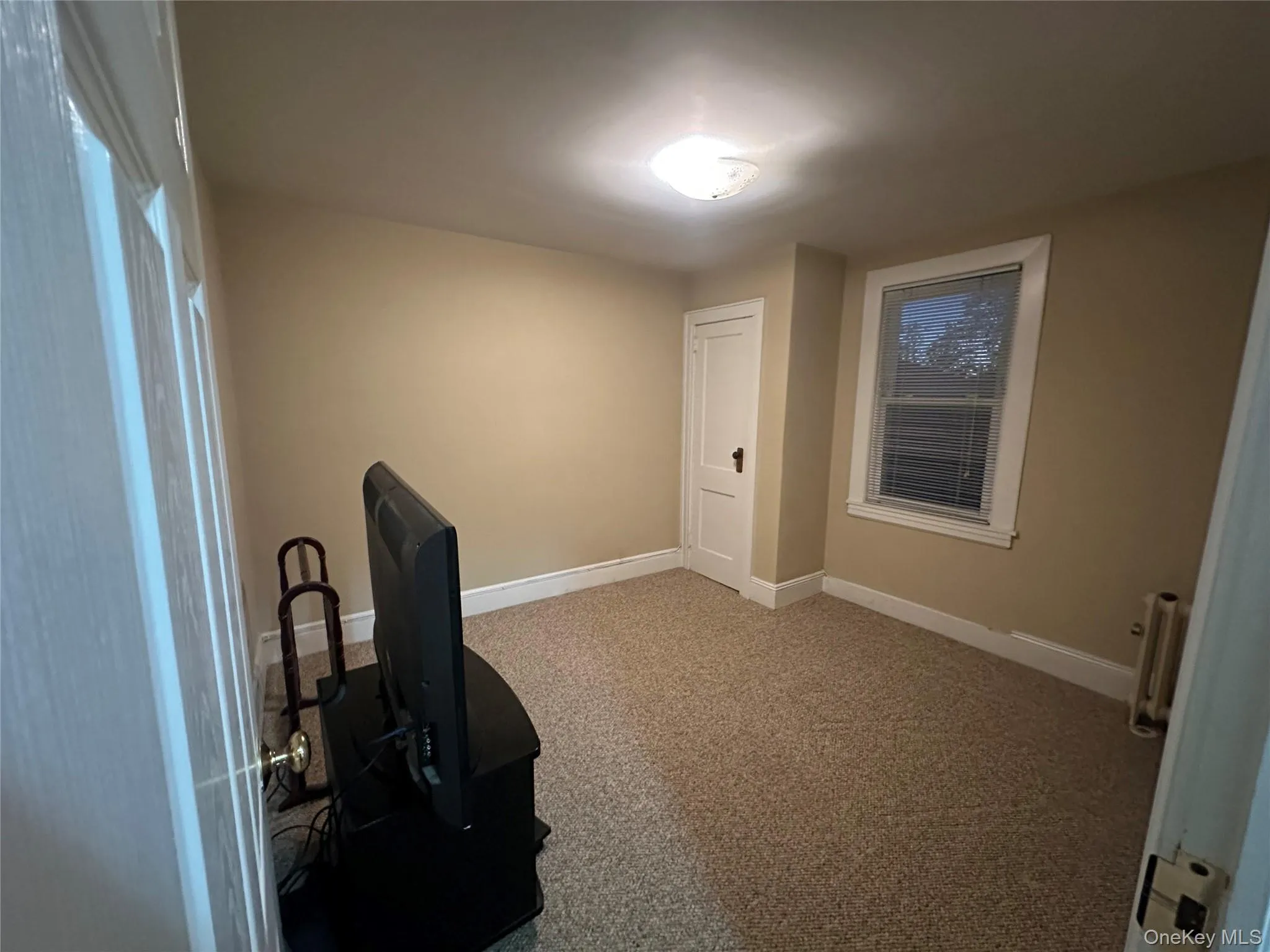 Office area featuring light colored carpet and radiator Office area featuring light colored carpet and radiator