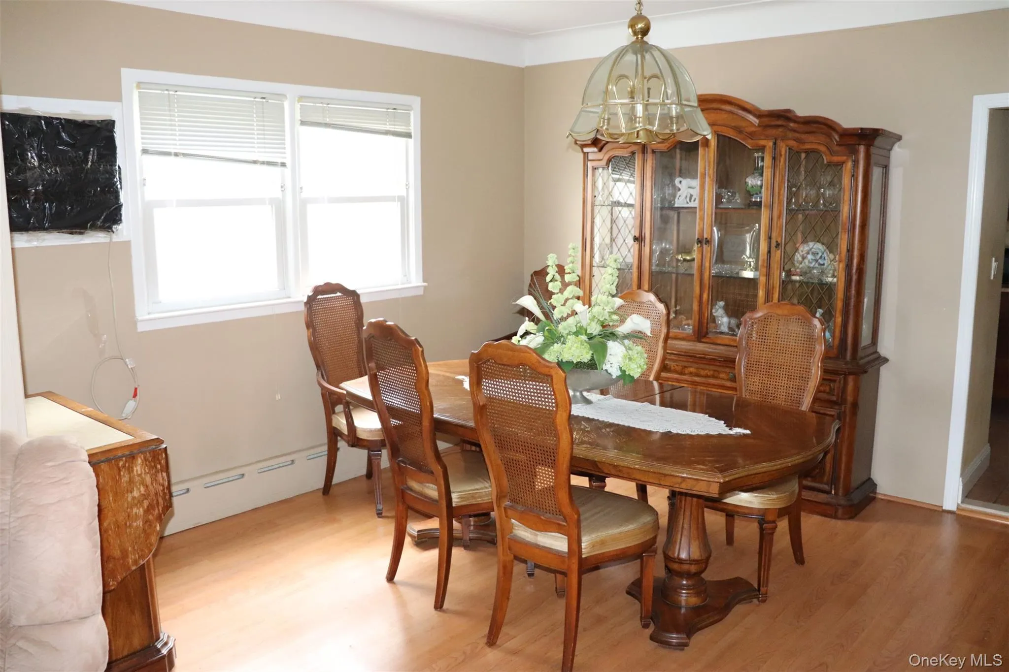 Dining space featuring wood finished floors, a chandelier, and baseboard heating Dining space featuring wood finished floors, a chandelier, and baseboard heating