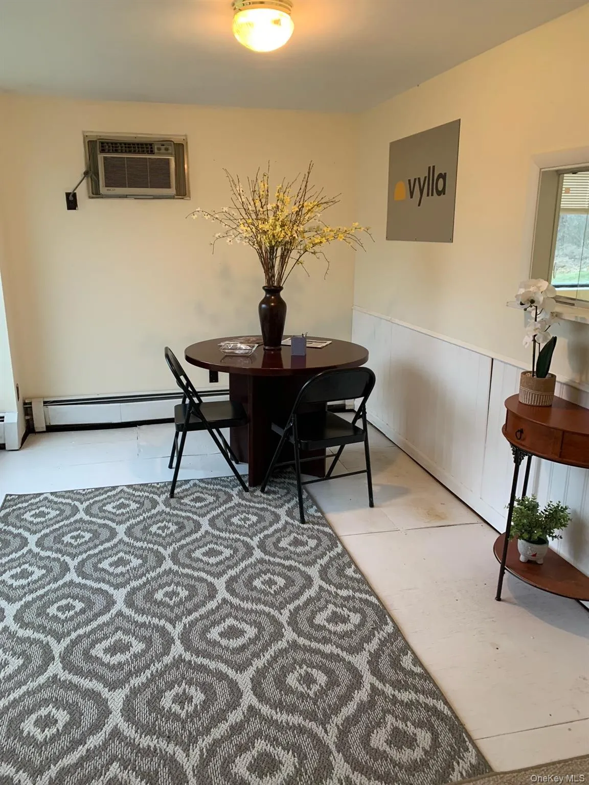 Dining space featuring wainscoting, baseboard heating, and a wall unit AC Dining space featuring wainscoting, baseboard heating, and a wall unit AC